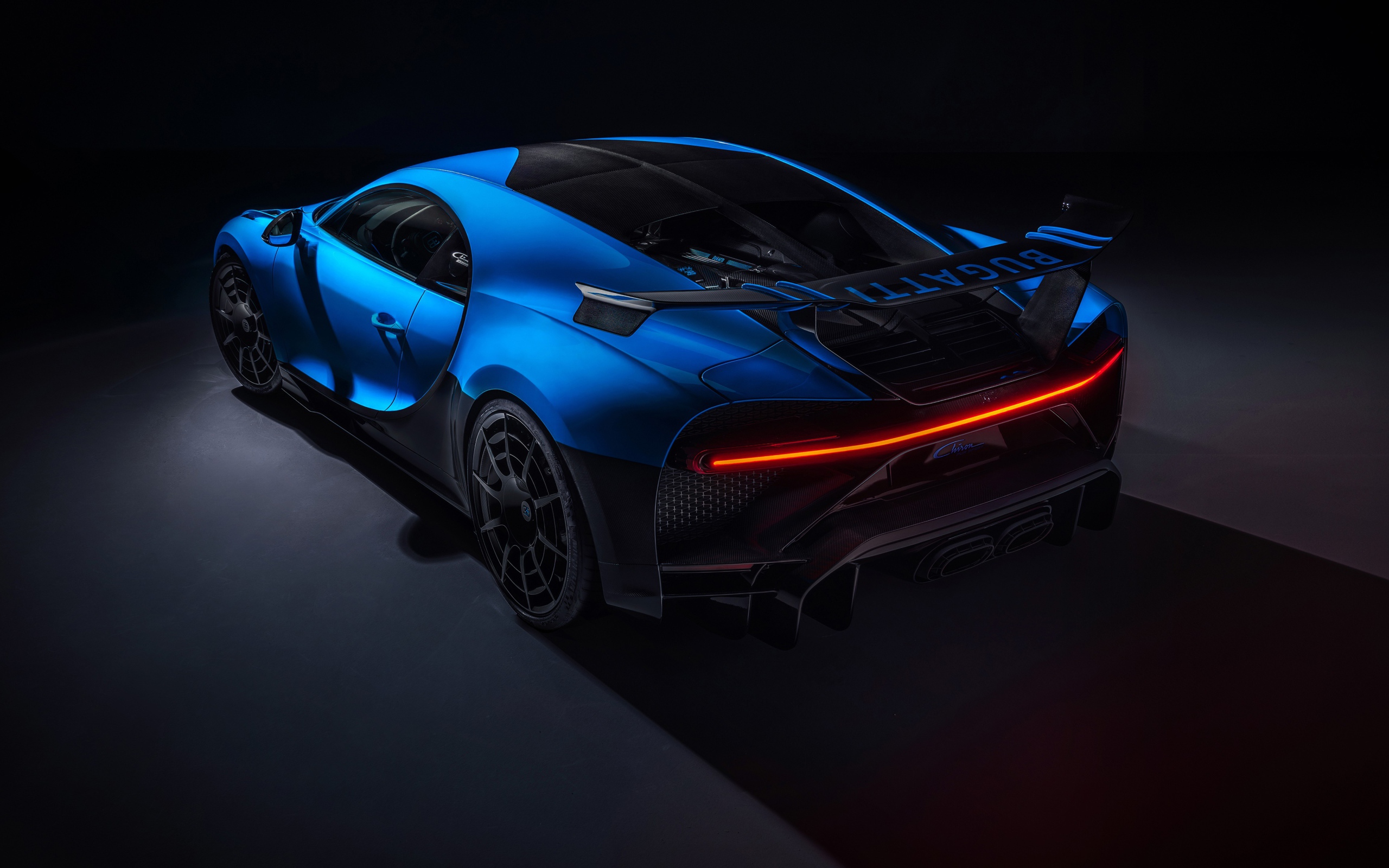 Синий автомобиль Bugatti Chiron Pur Sport 2020 года вид сзади на черном фоне