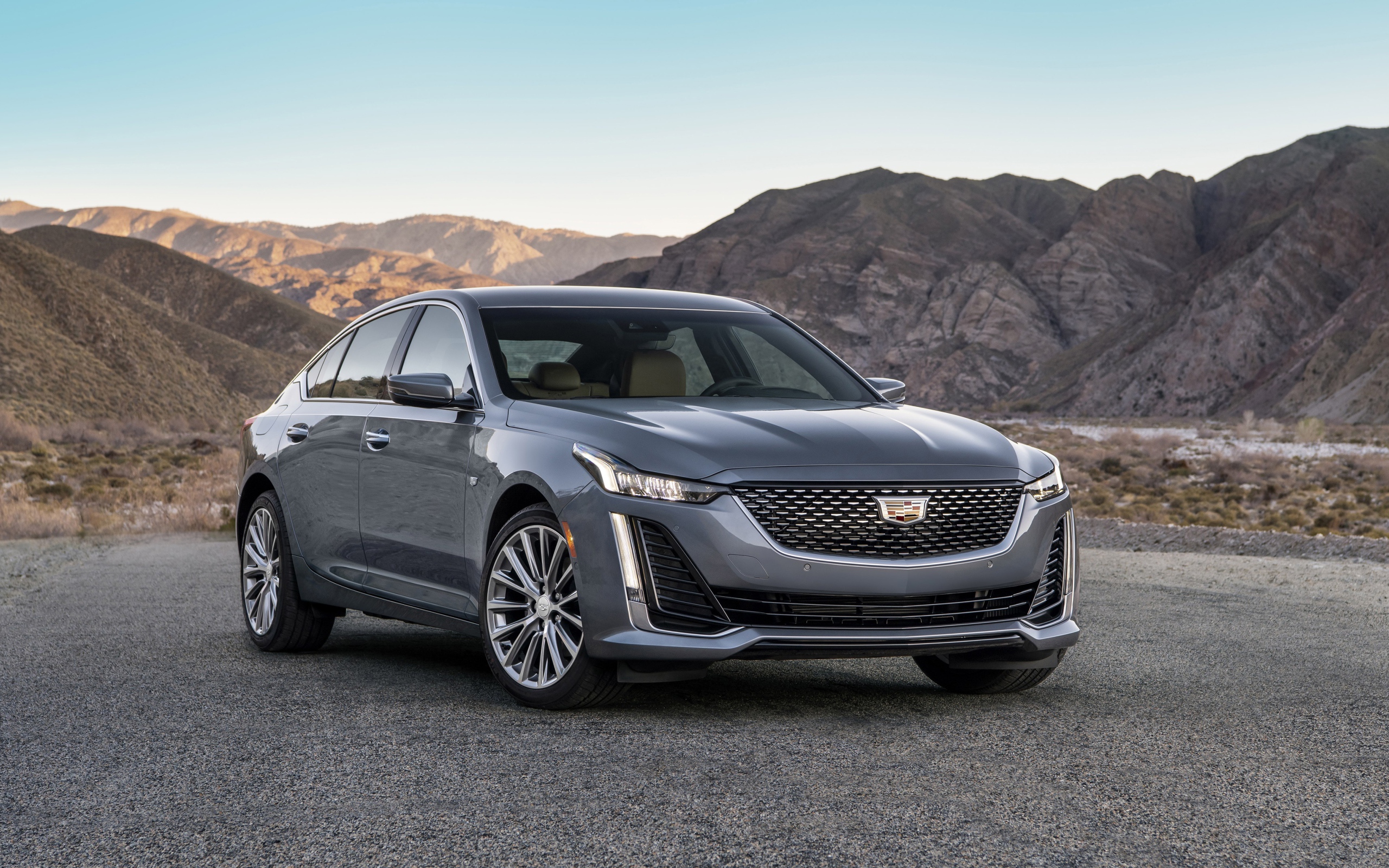 Серебристый автомобиль Cadillac CT5 Premium, 2020 года на фоне гор 