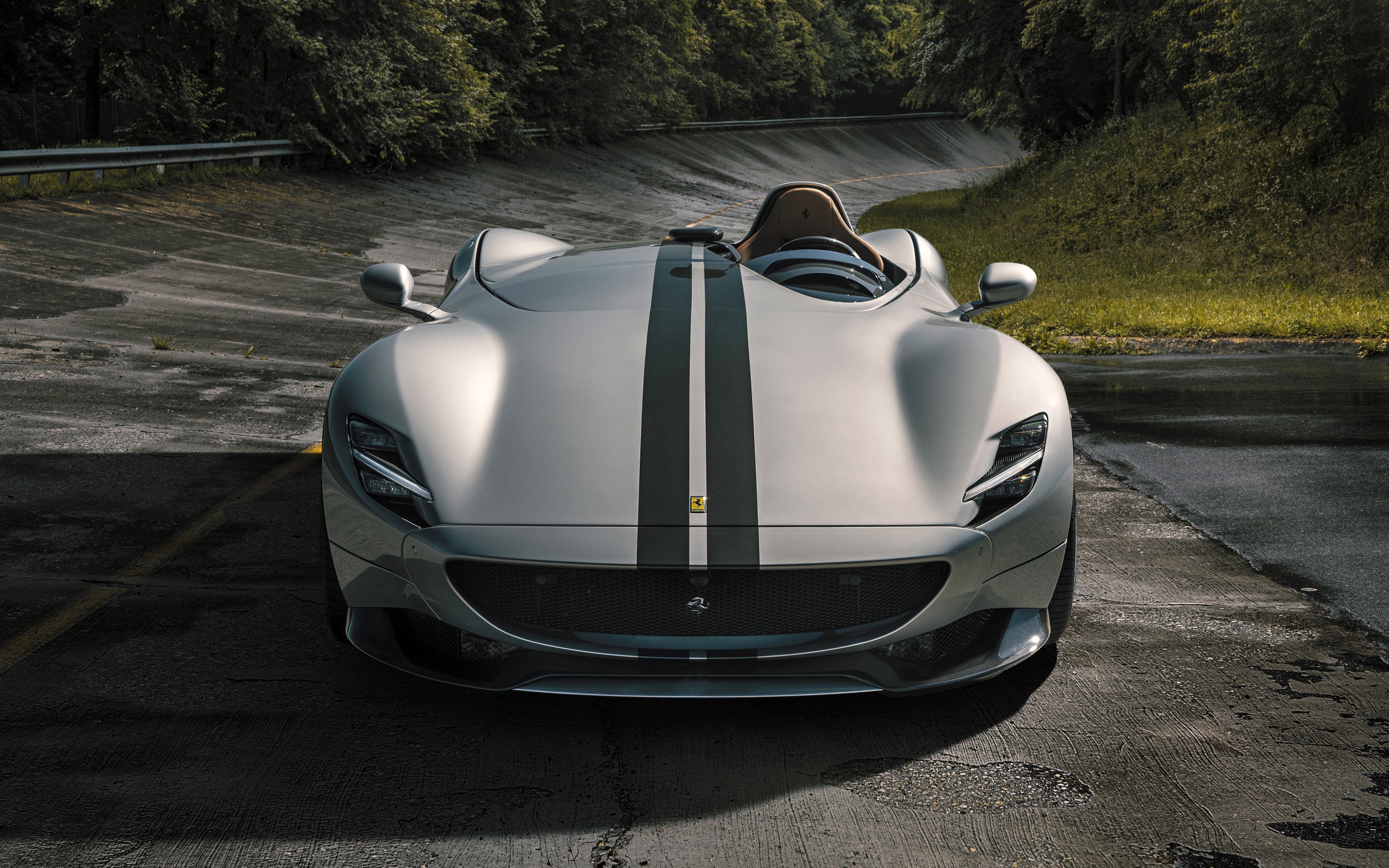 Серебристый кабриолет  Ferrari Monza SP1 2020 года на мокрой трассе 