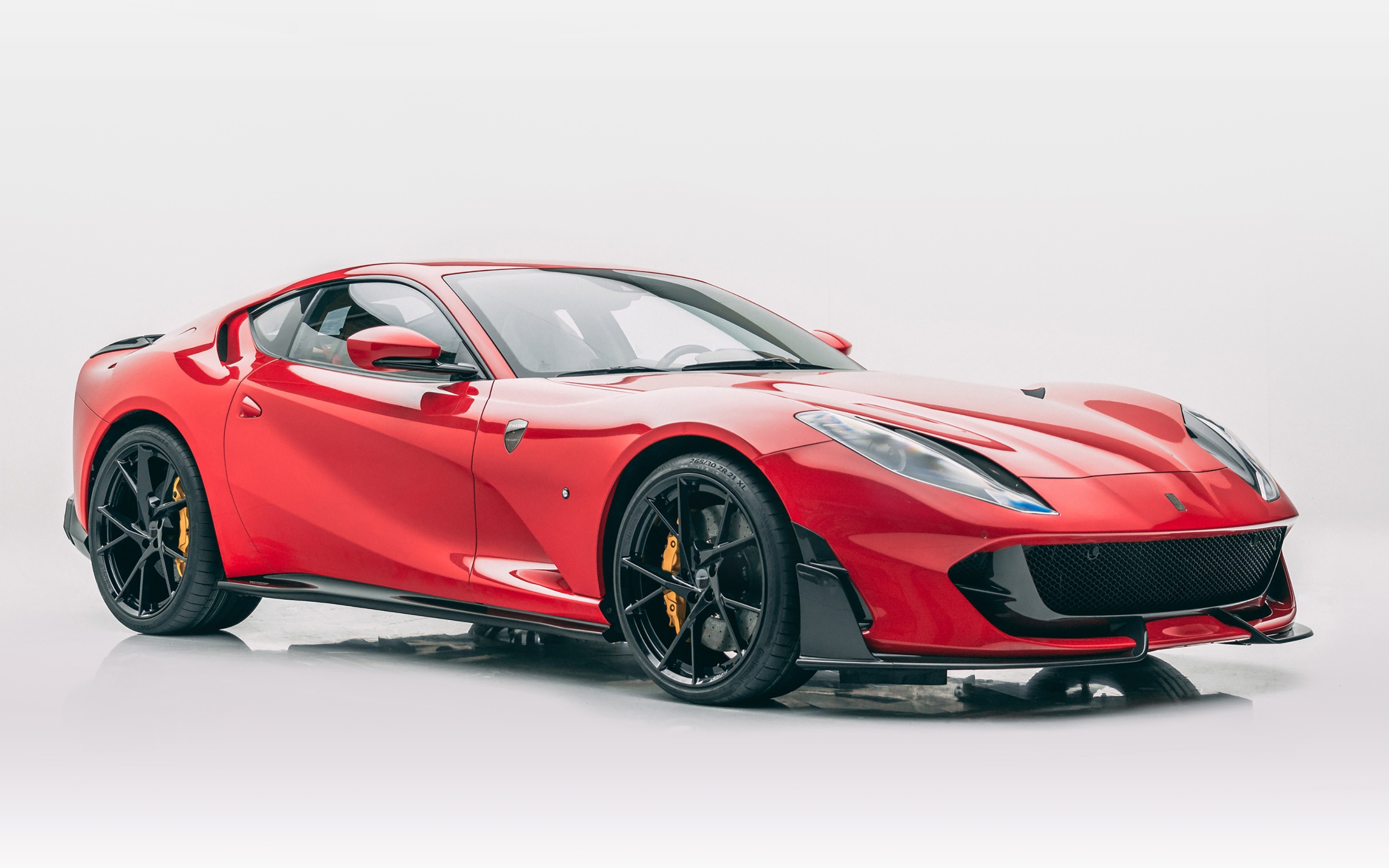 Красный быстрый автомобиль Mansory Ferrari 812 Superfast Soft Kit 2020 года на сером фоне
