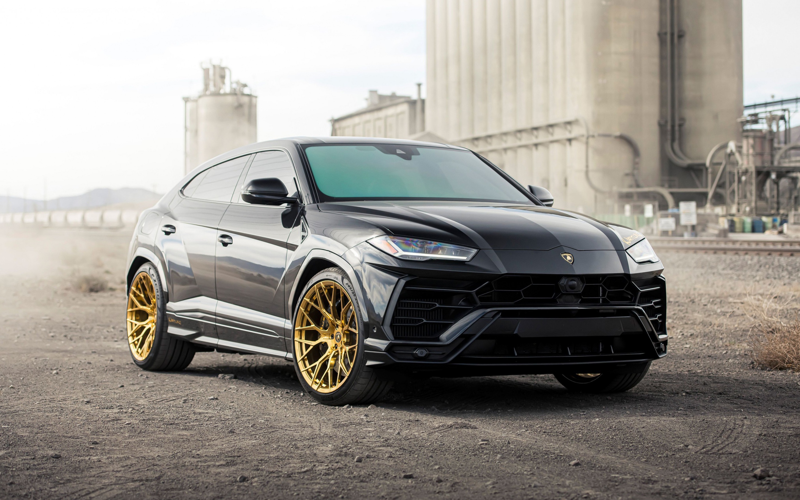Черный внедорожник  Lamborghini Urus 2020 года на фоне завода
