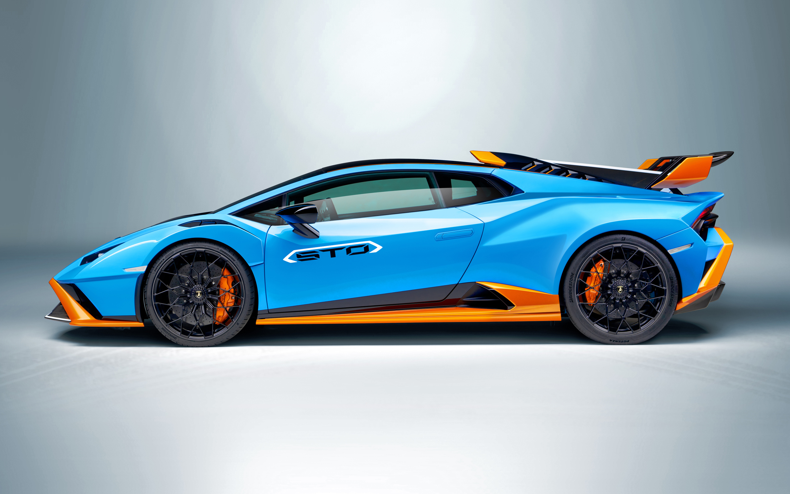 Голубой автомобиль Lamborghini Huracán STO 2021 года вид сбоку