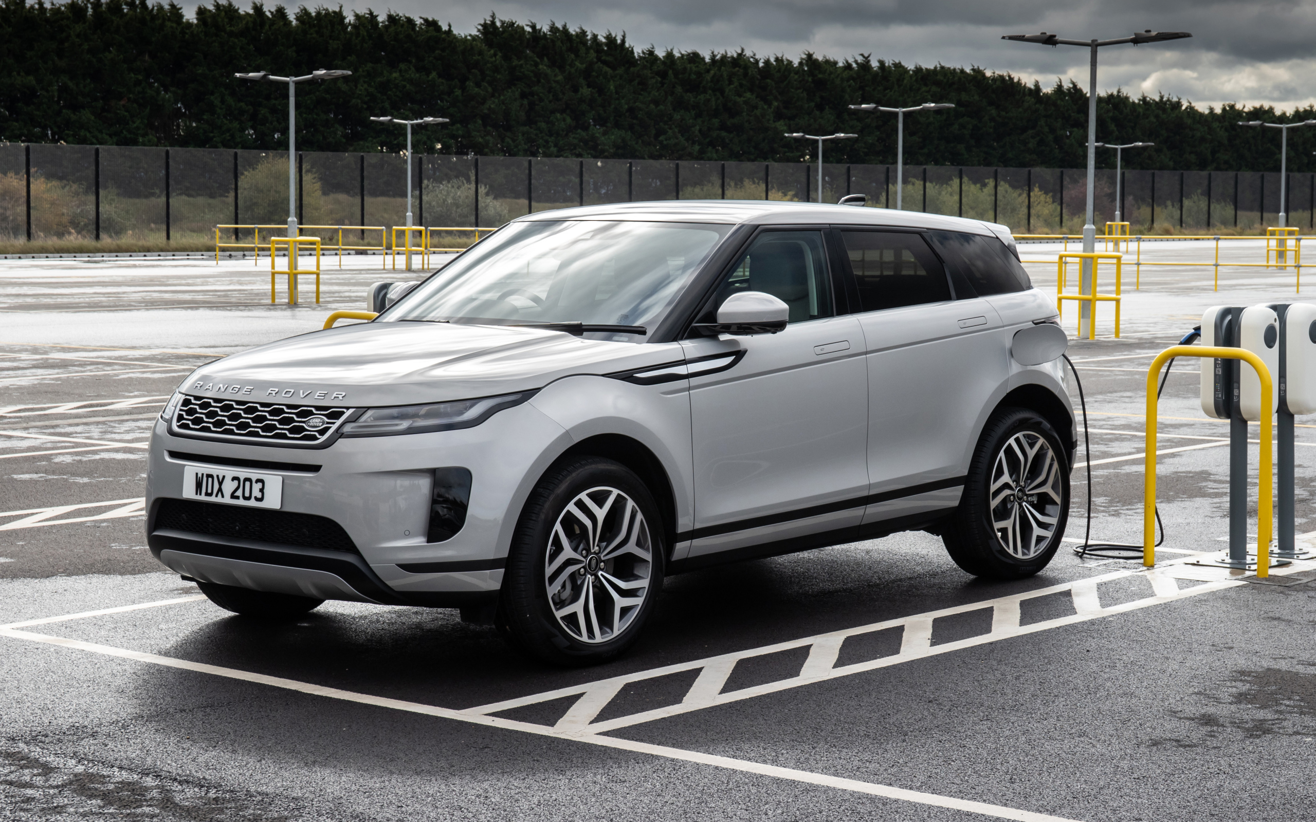 Серебристый автомобиль Range Rover Evoque P300e S 2020 года на заправке