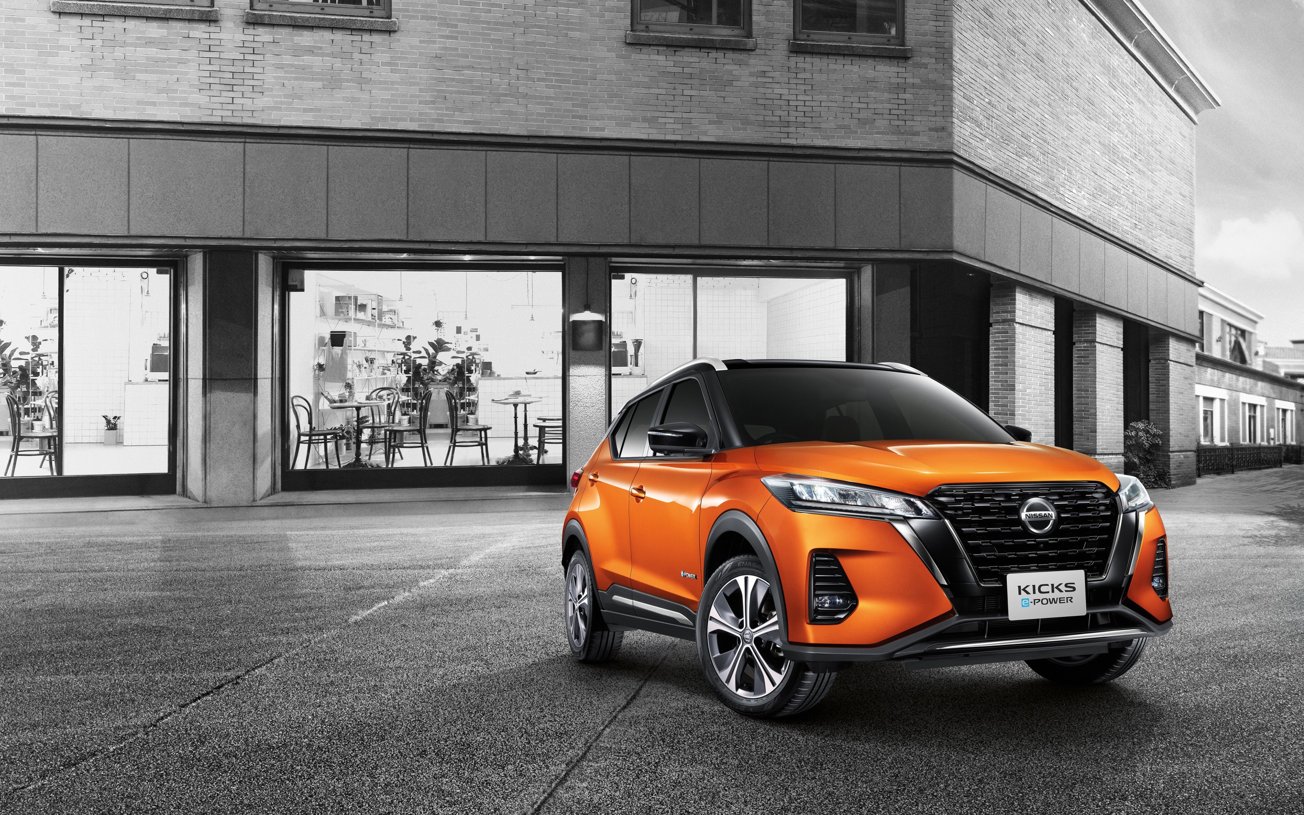 Оранжевый внедорожник Nissan Kicks E-POWER 2020 года у кафе