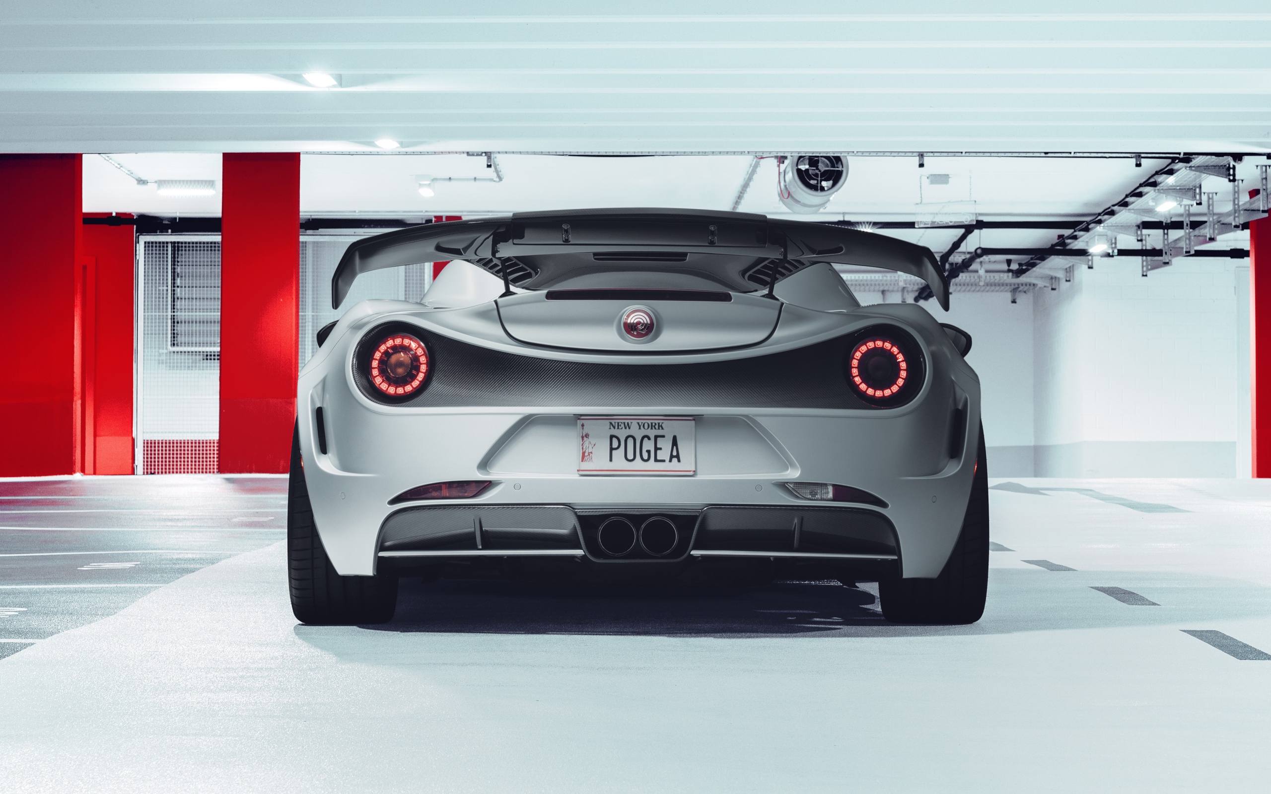 Серый автомобиль Pogea Racing Nemesis 2020 года вид сзади