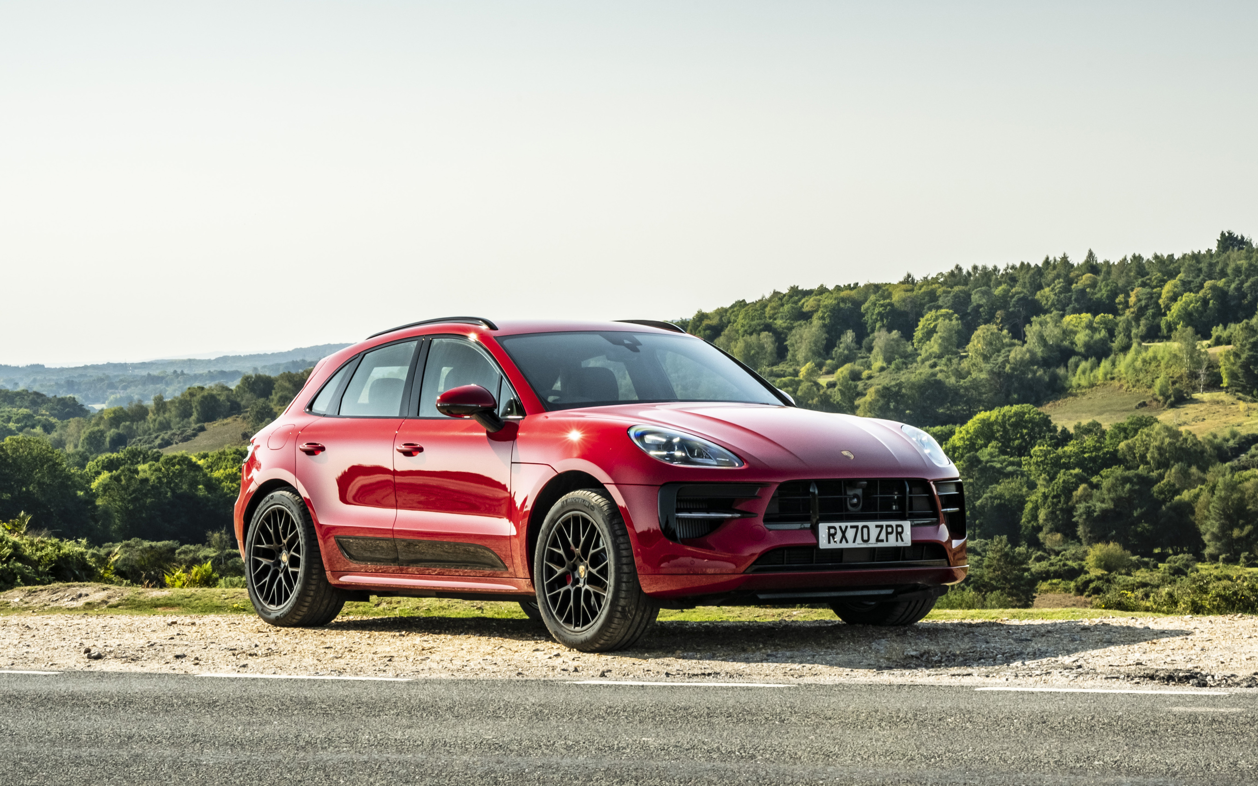 Красный автомобиль Porsche Macan GTS 2020  года в лучах солнца