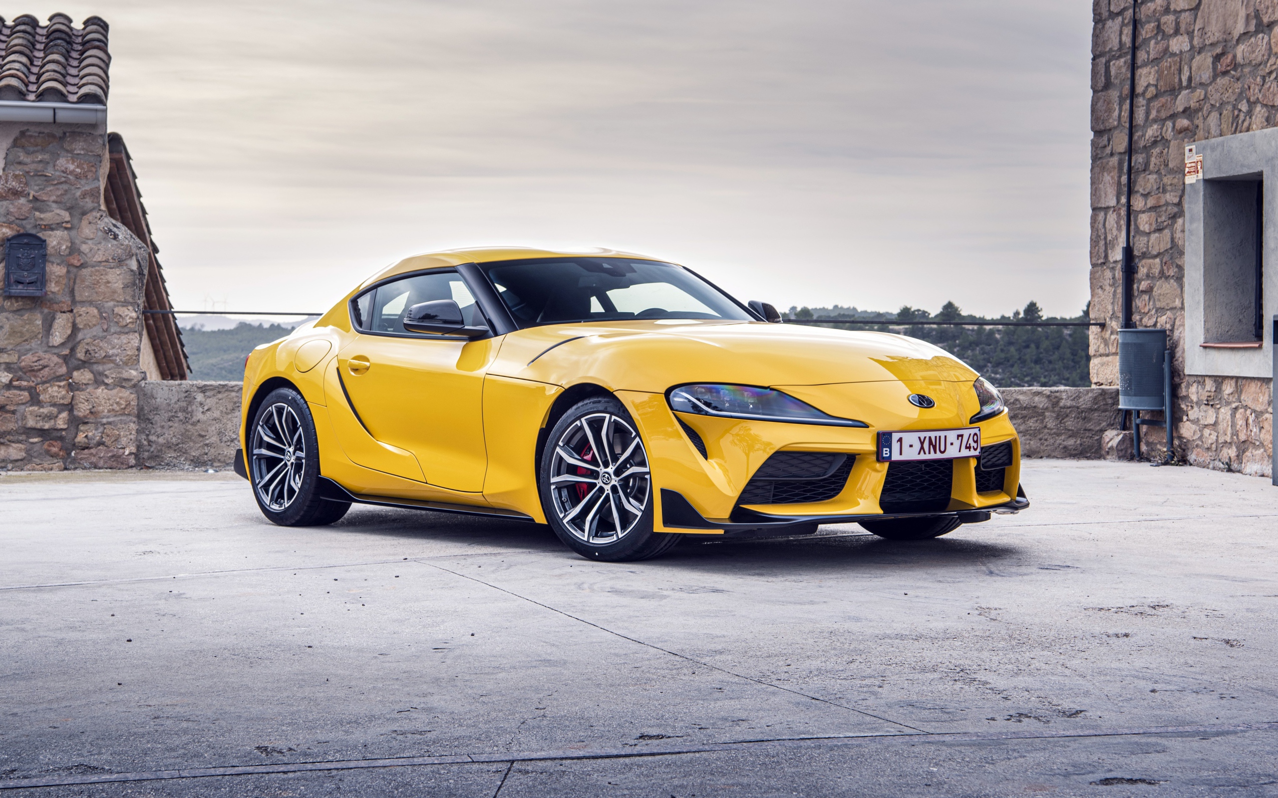 Желтый автомобиль Toyota GR Supra 2 2020 года у здания 