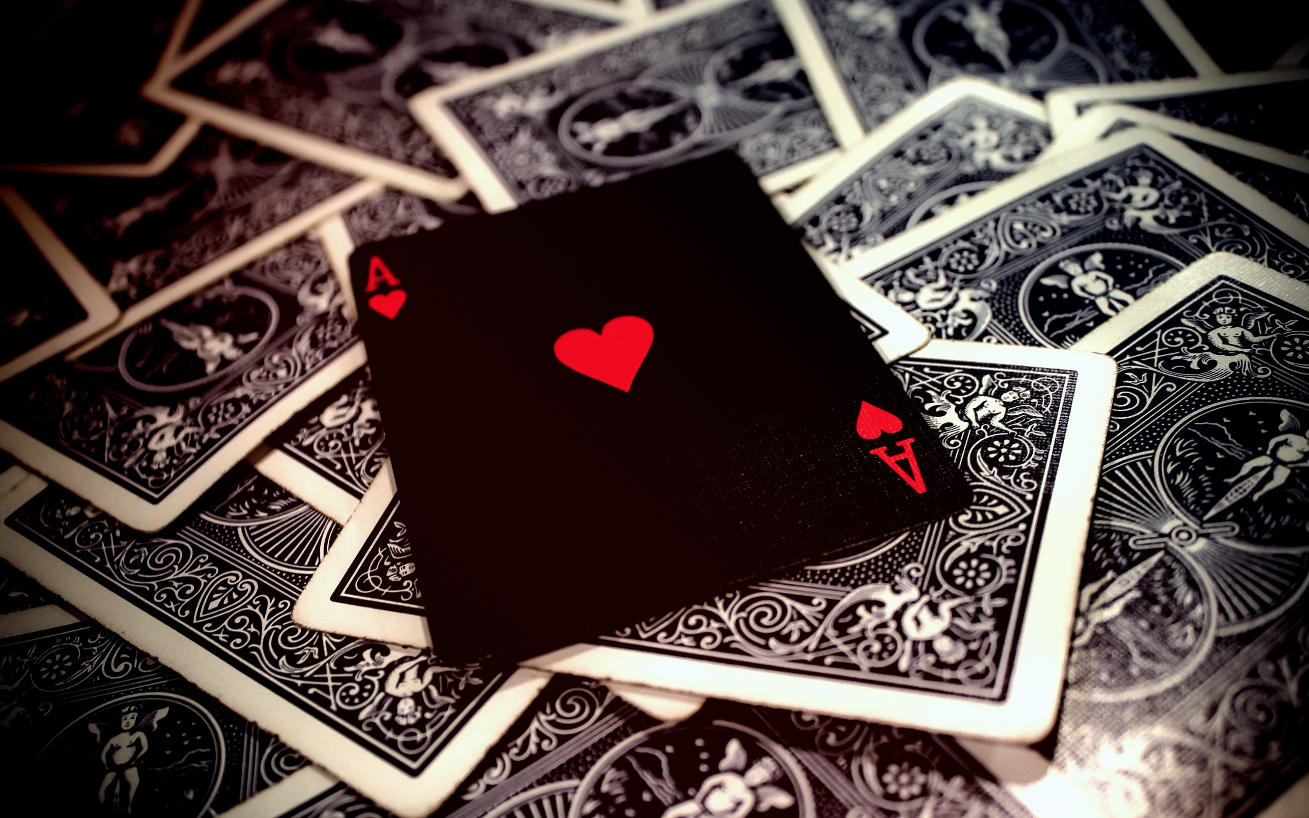 Black card ace of hearts on the table with a deck