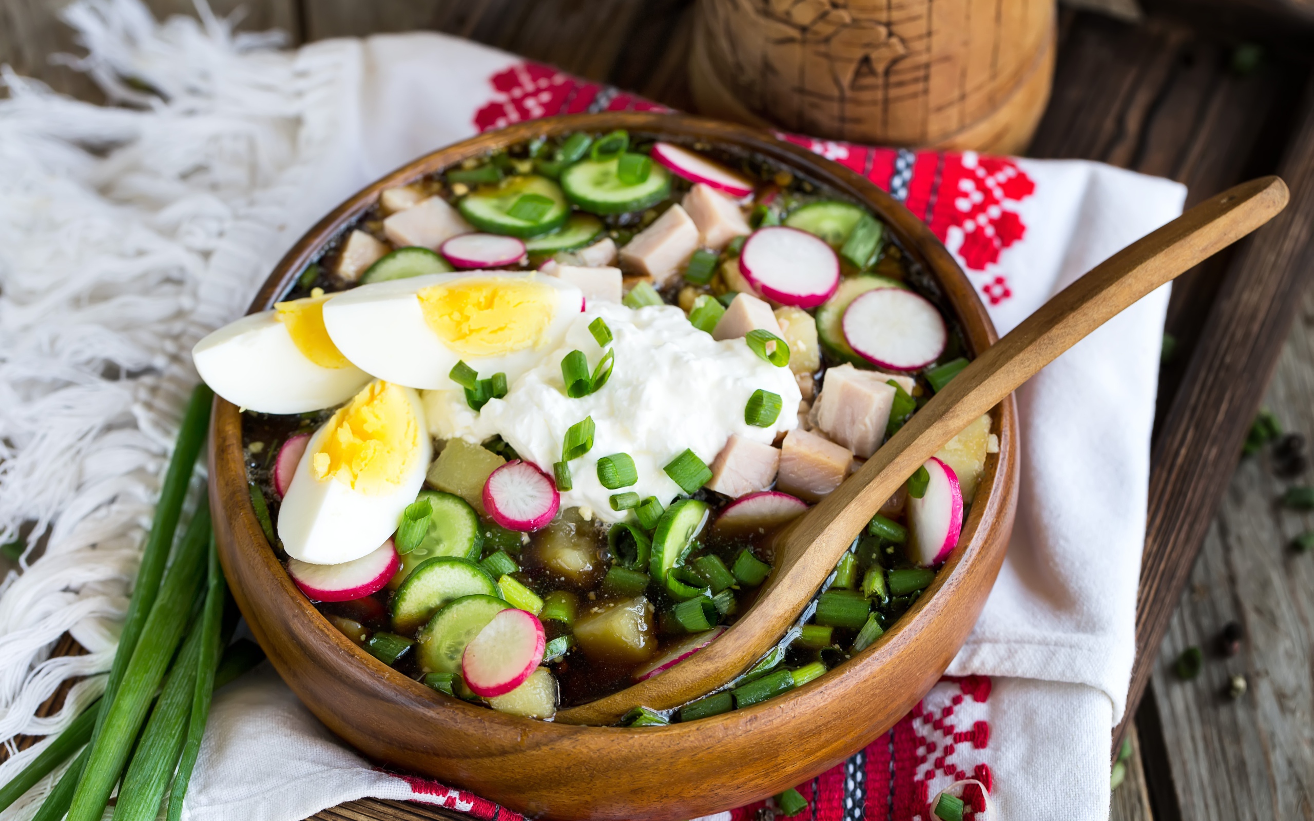 Холодная окрошка в деревянной миске на столе 
