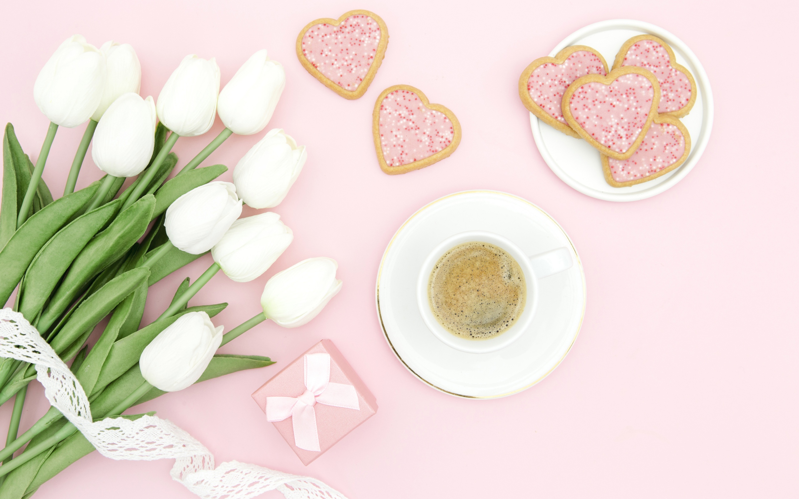 Чашка кофе с печеньем на столе с букетом белых тюльпанов