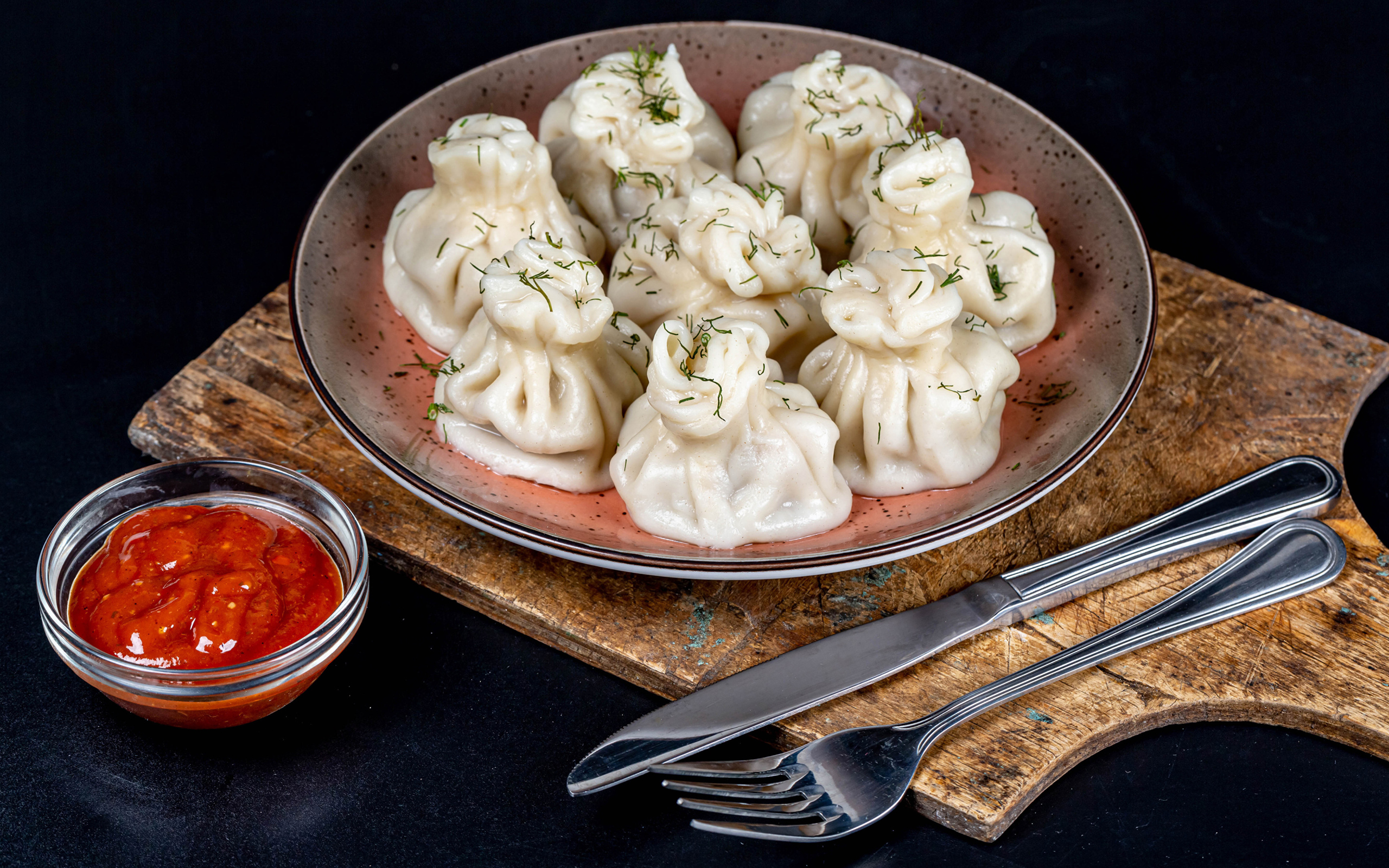 Вкусные горячие хинкали на столе с соусом