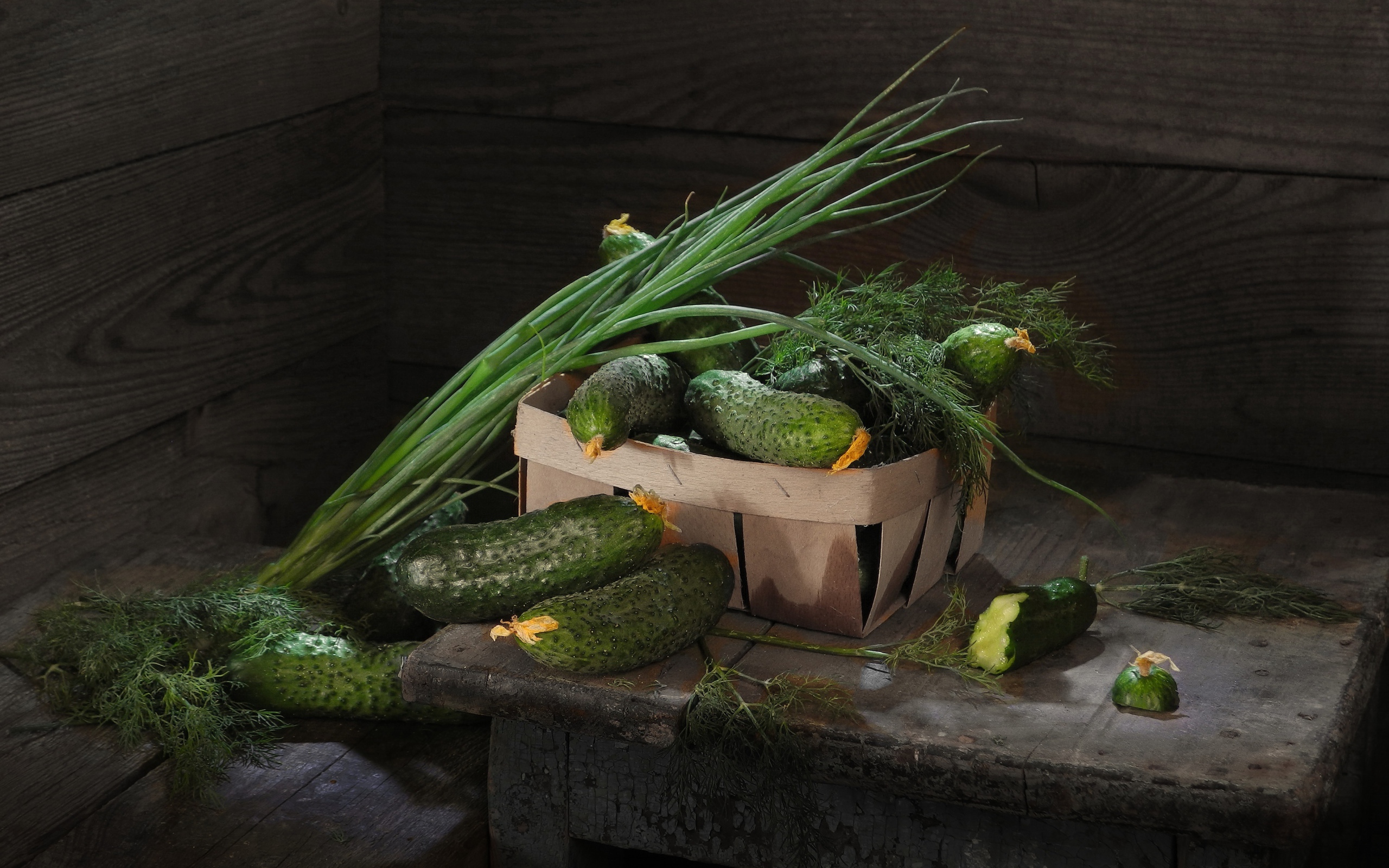 Свежие огурцы на столе  с зеленым луком и укропом