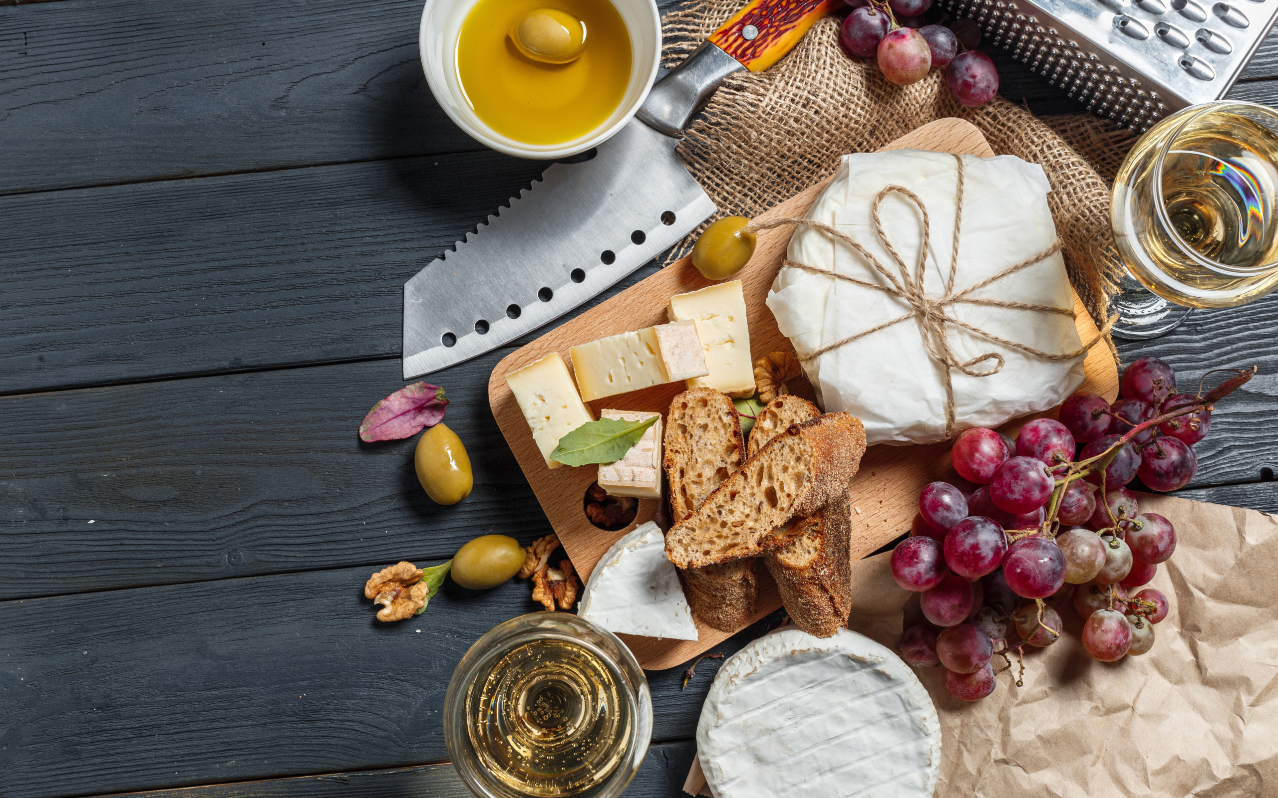 Виноград на столе с сыром, хлебом и оливками