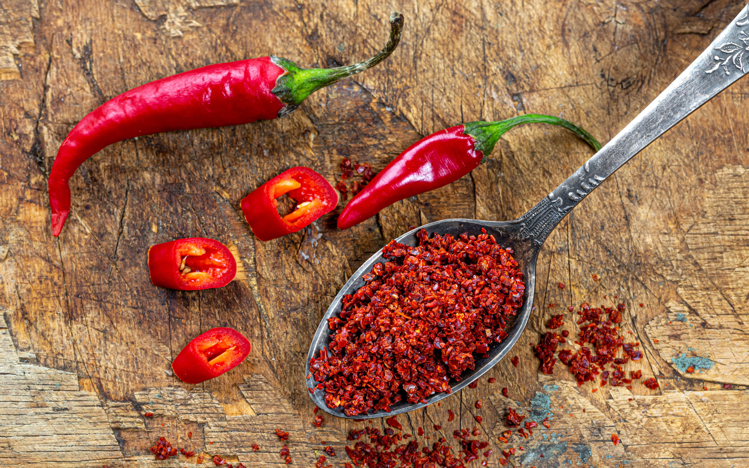 Молотый красный перец на ложке на столе 