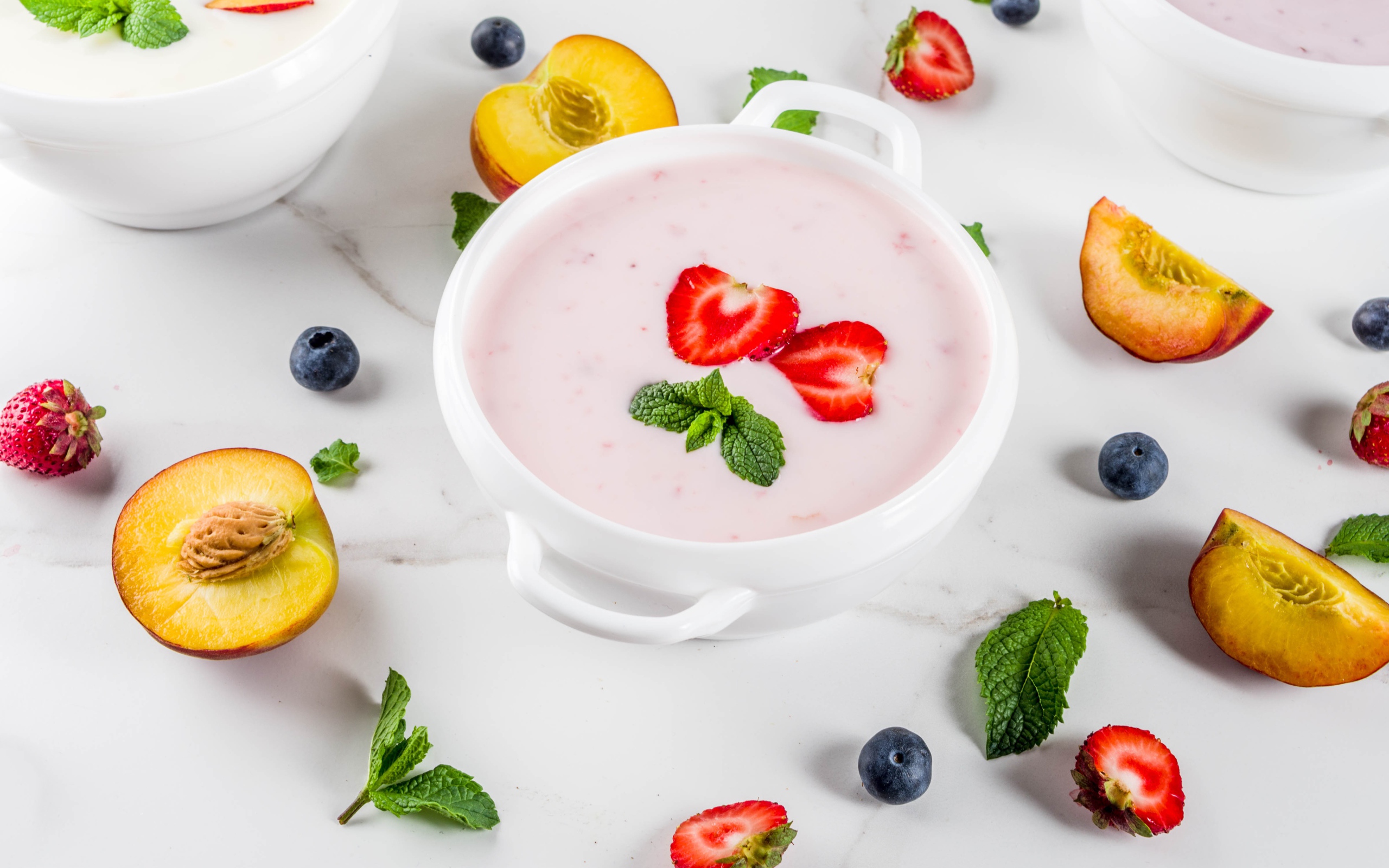 Молочный суп в тарелке на столе с ягодами и нектарином