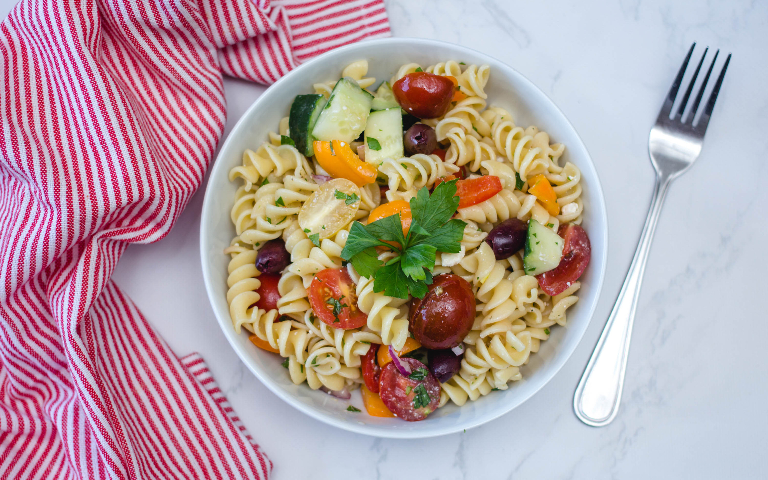 Макароны в тарелке с овощами на столе 