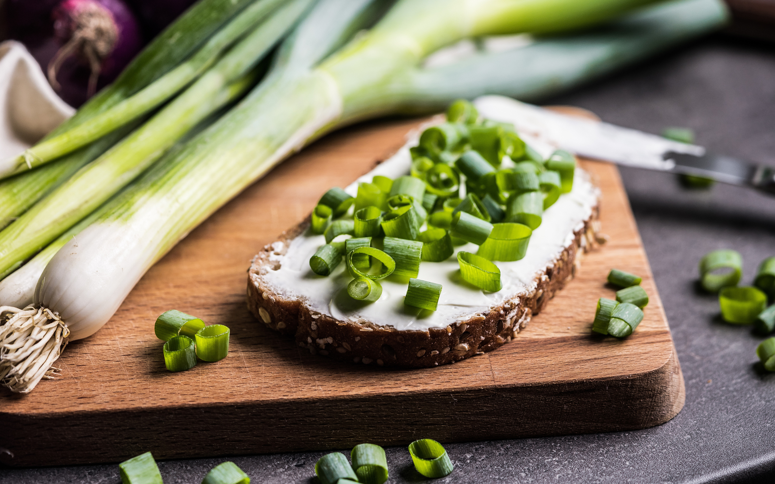Бутерброд с маслом и зеленым луком на столе 