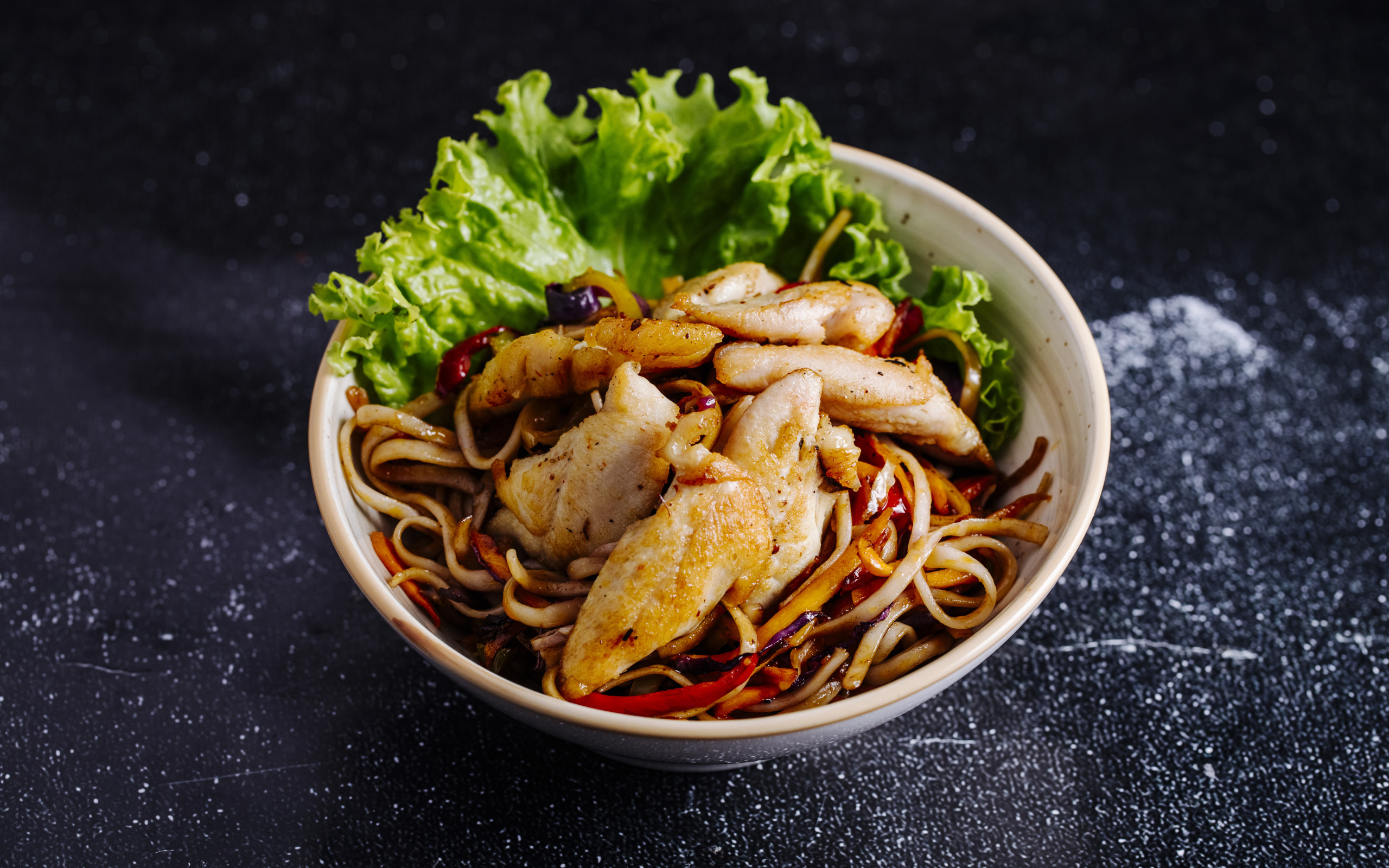 Спагетти в соусе с курицей и листьями салата 