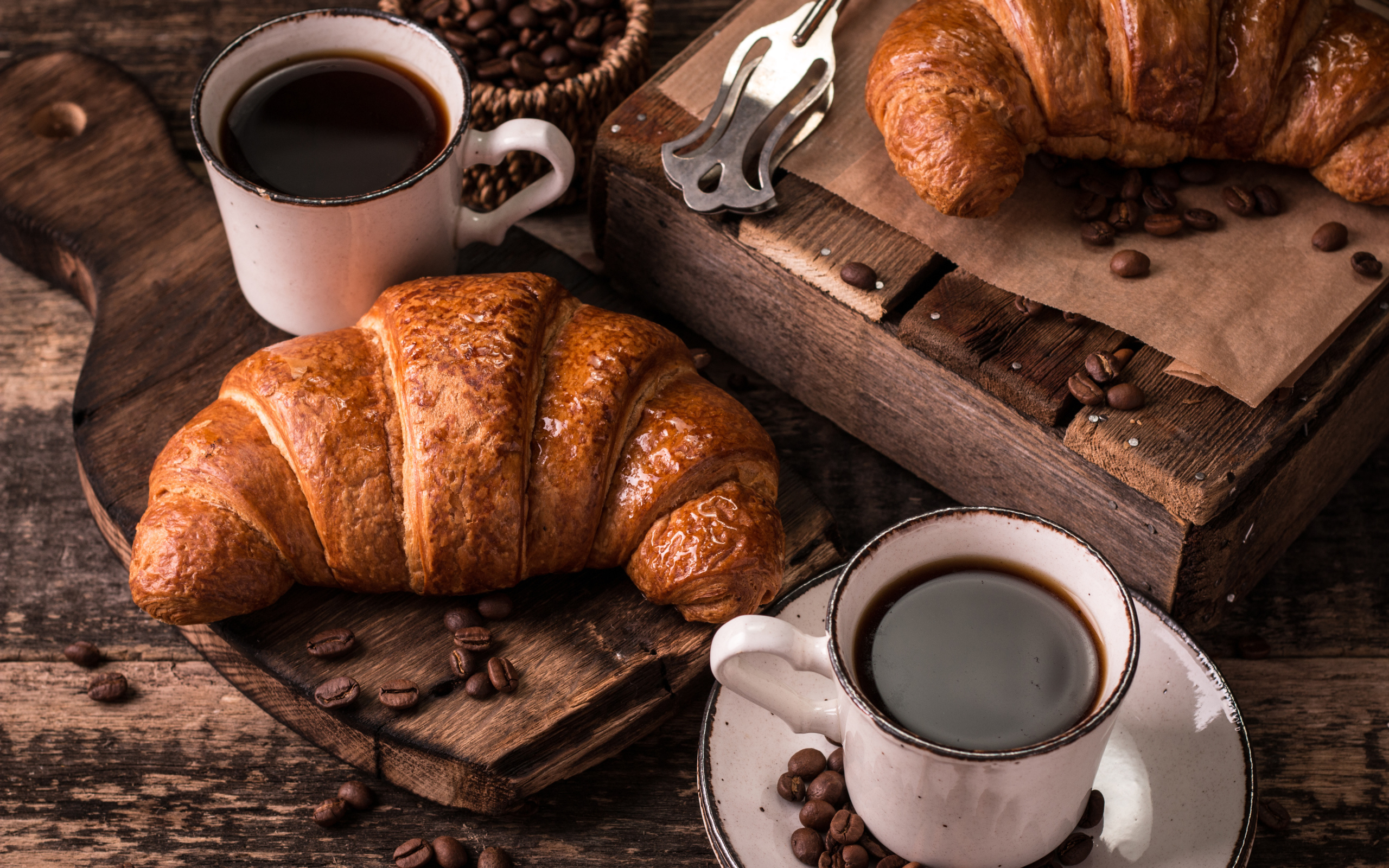 Две чашки кофе на столе с рогаликами и зернами 