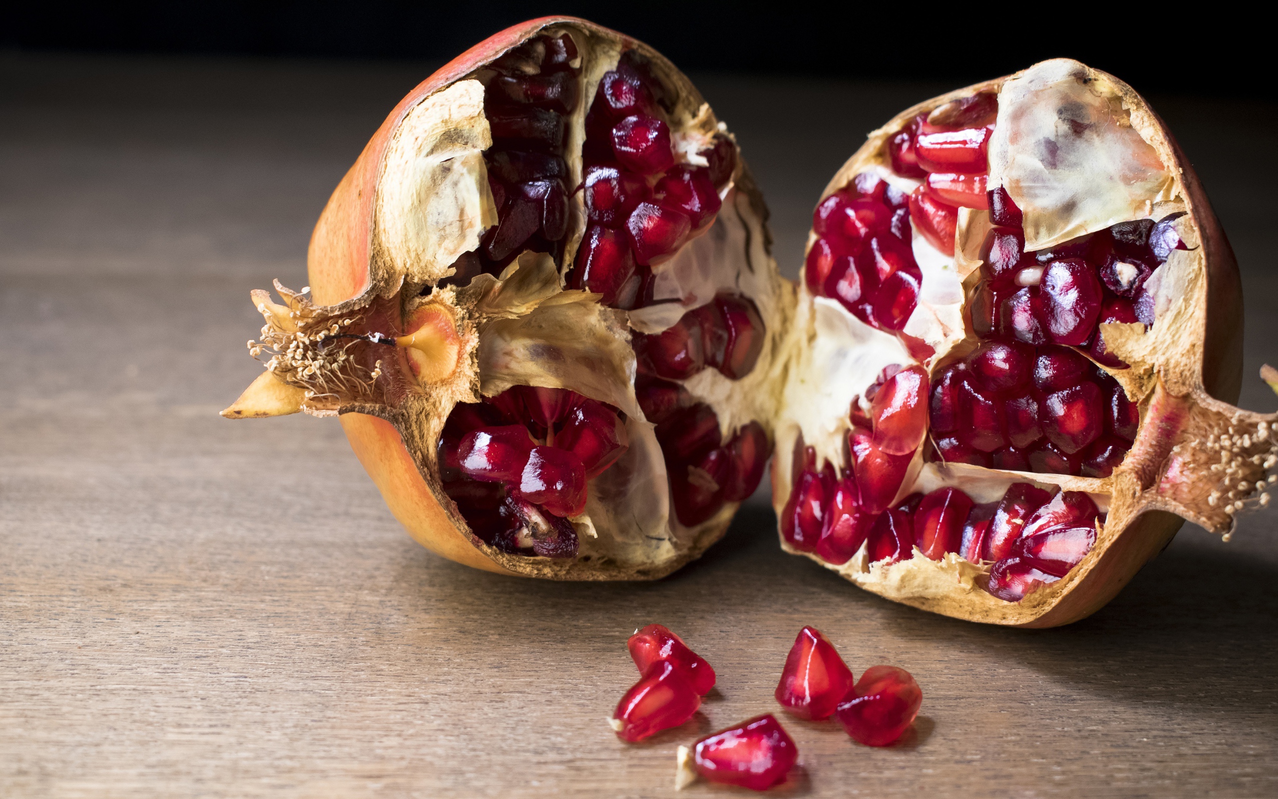 Разломанный красный гранат на столе 