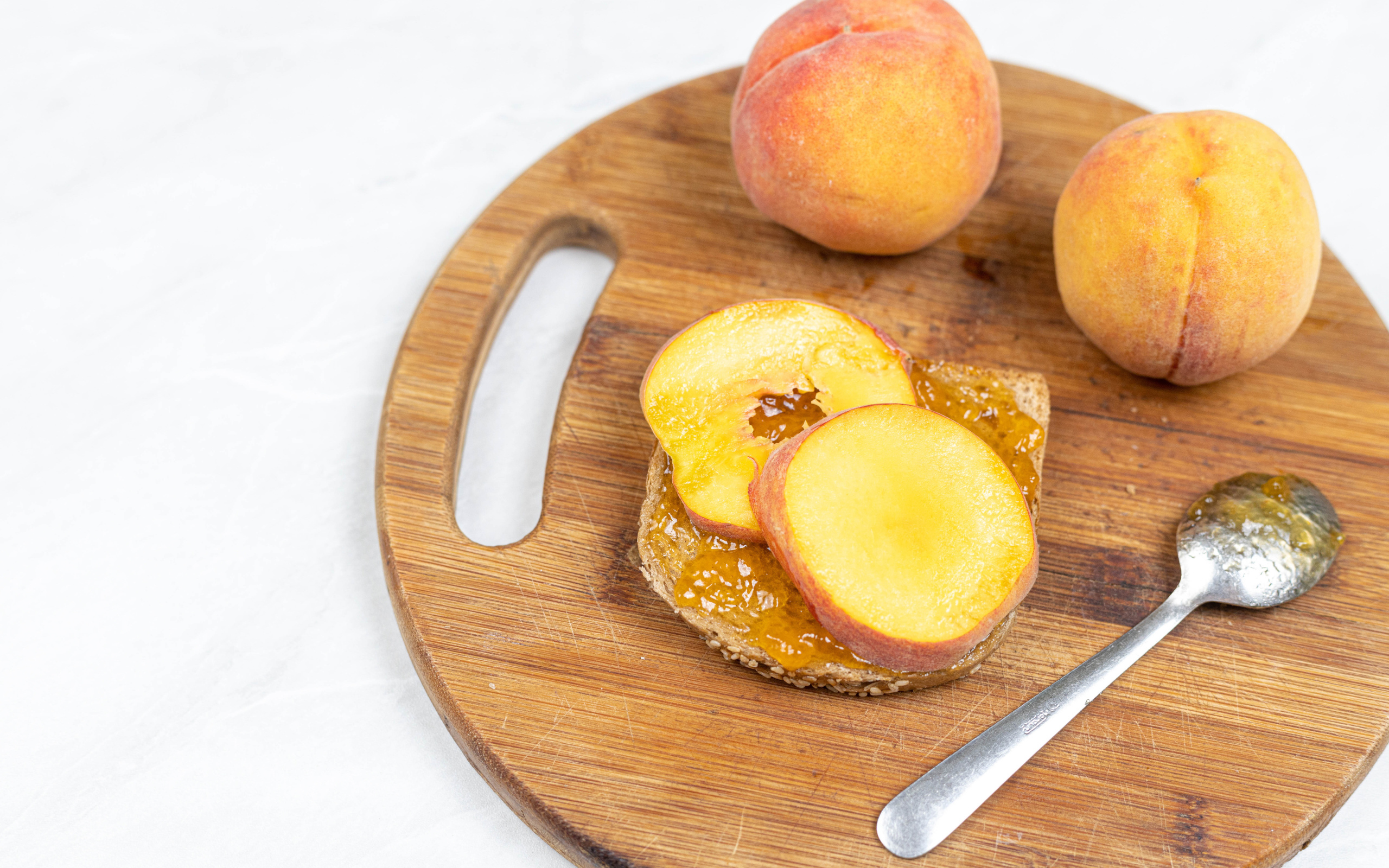 Свежие персики на столе с хлебом 