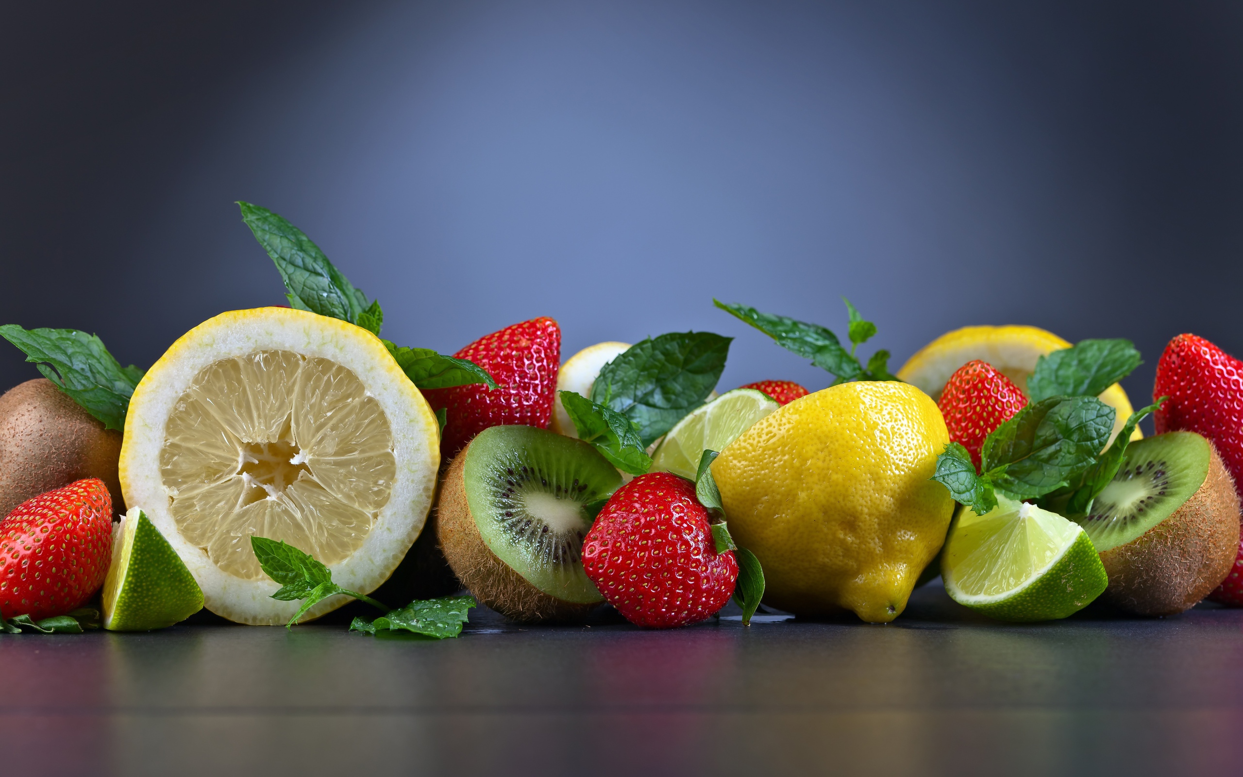 Лимоны на столе с киви и ягодами клубники 