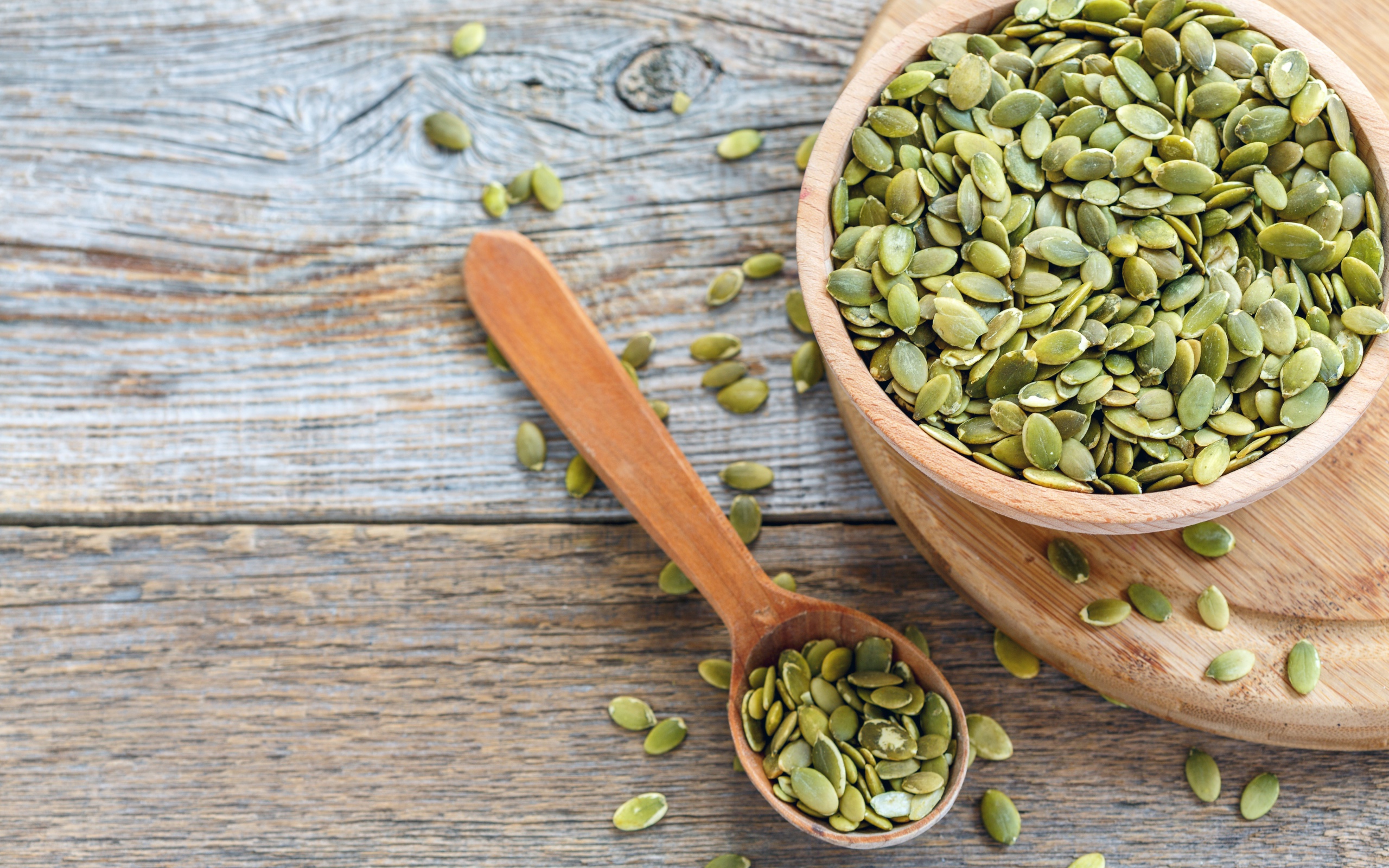 Тыквенные семечки в деревянной посуде на столе