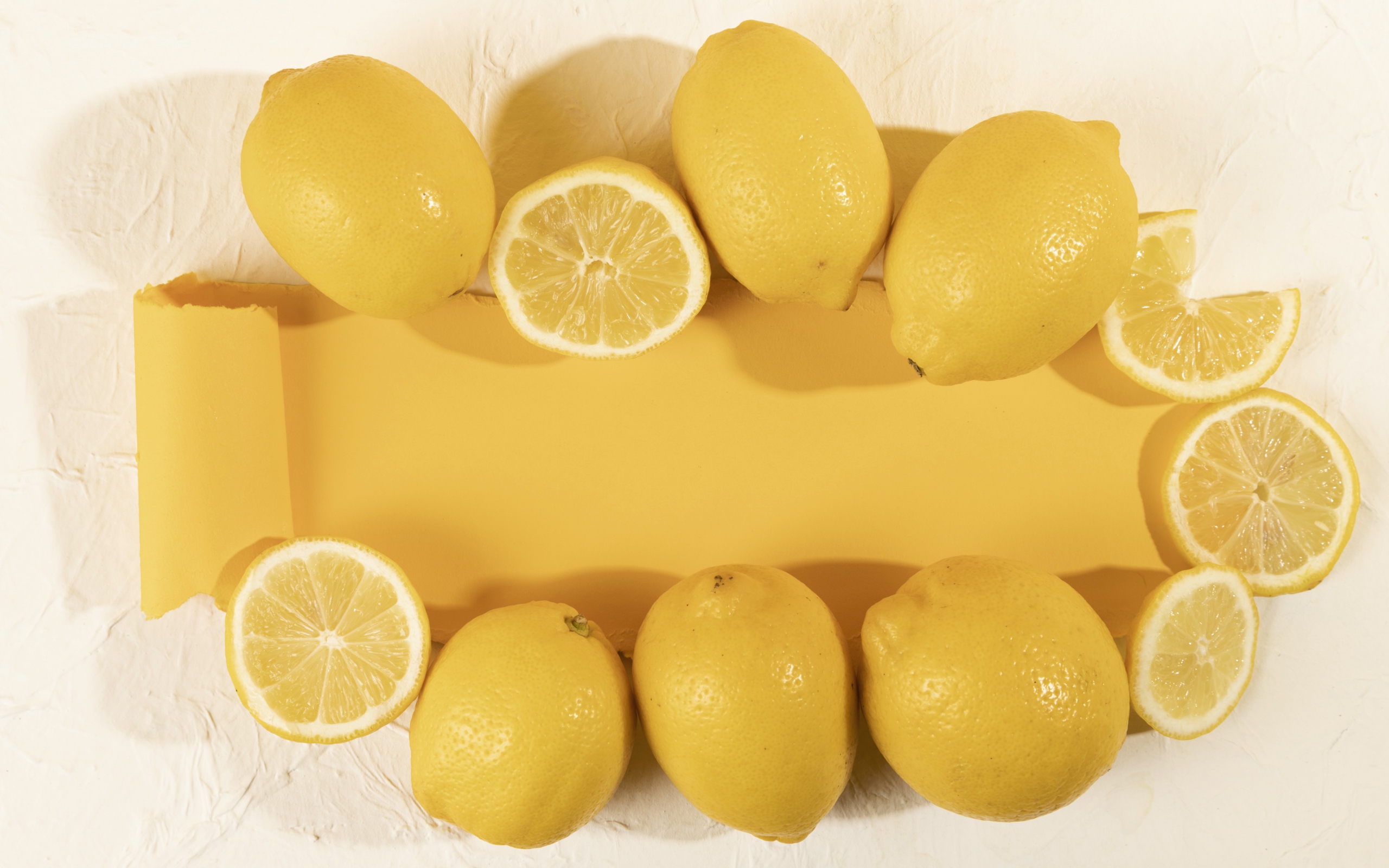 Желтые лимоны на белом фоне с листом бумаги
