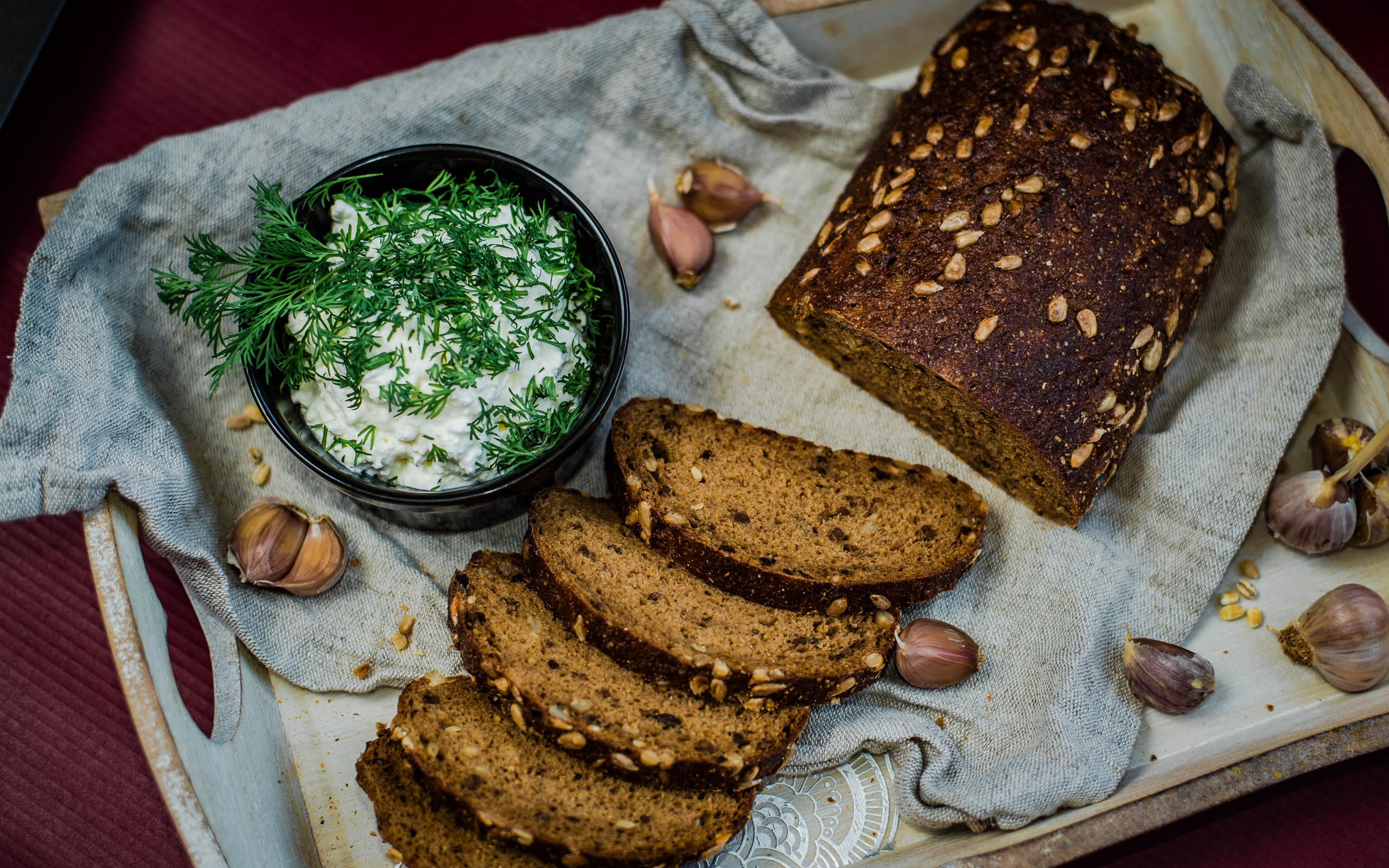 Fresh bread with grains on the table with sauce and garlic