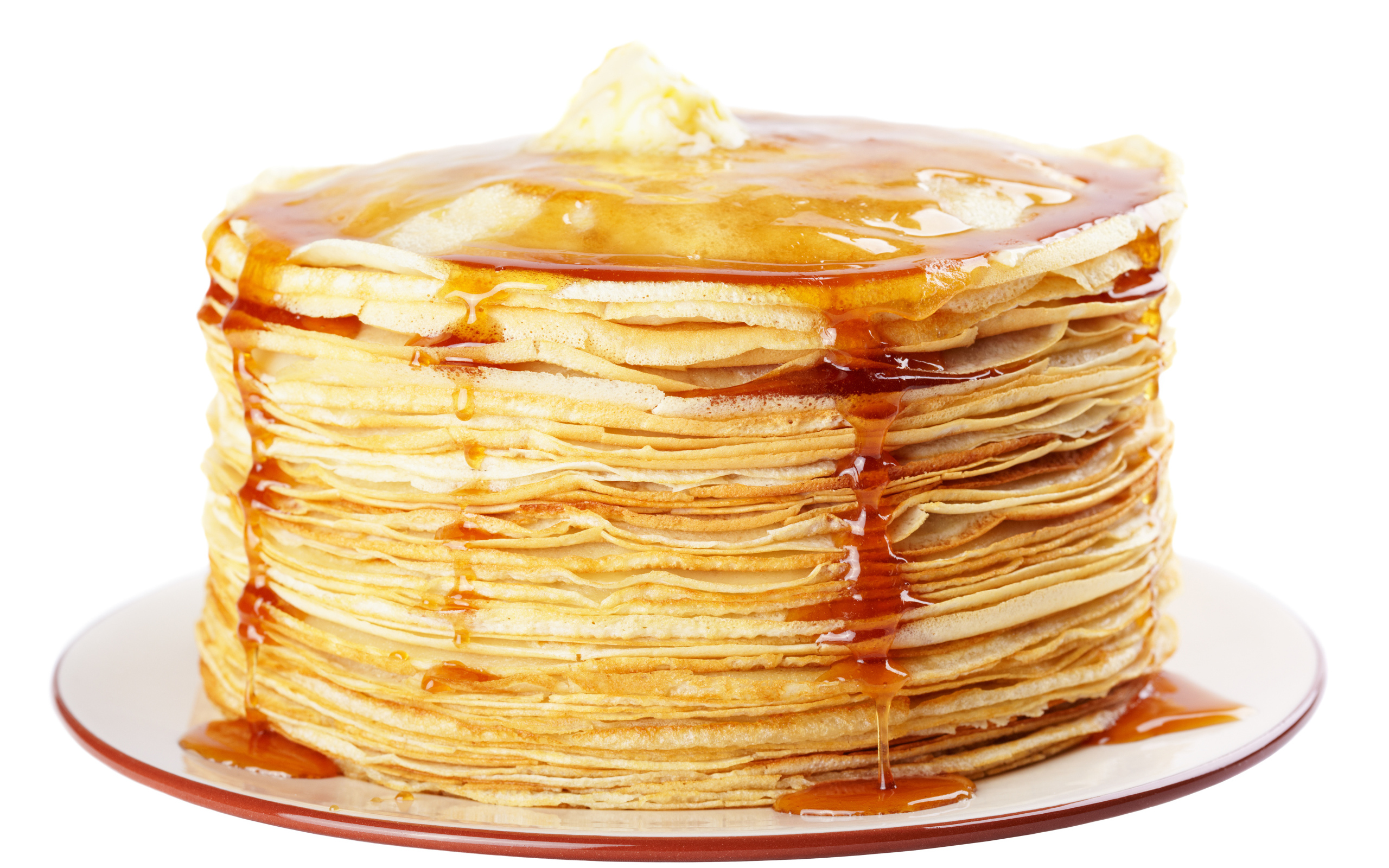 Тонкие блины с медом на тарелке на белом фоне