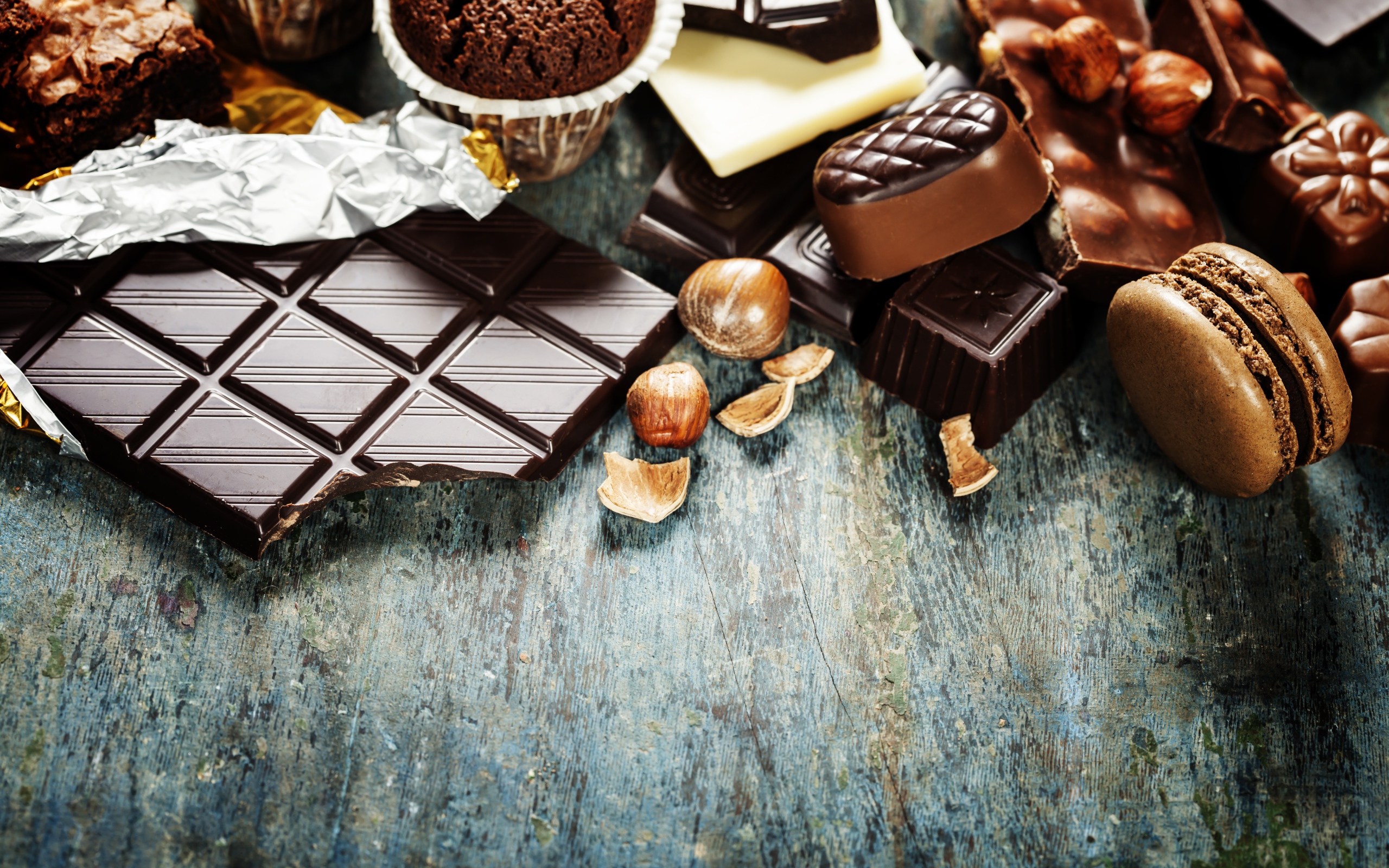Шоколад на столе с орехами, кексами и конфетами 