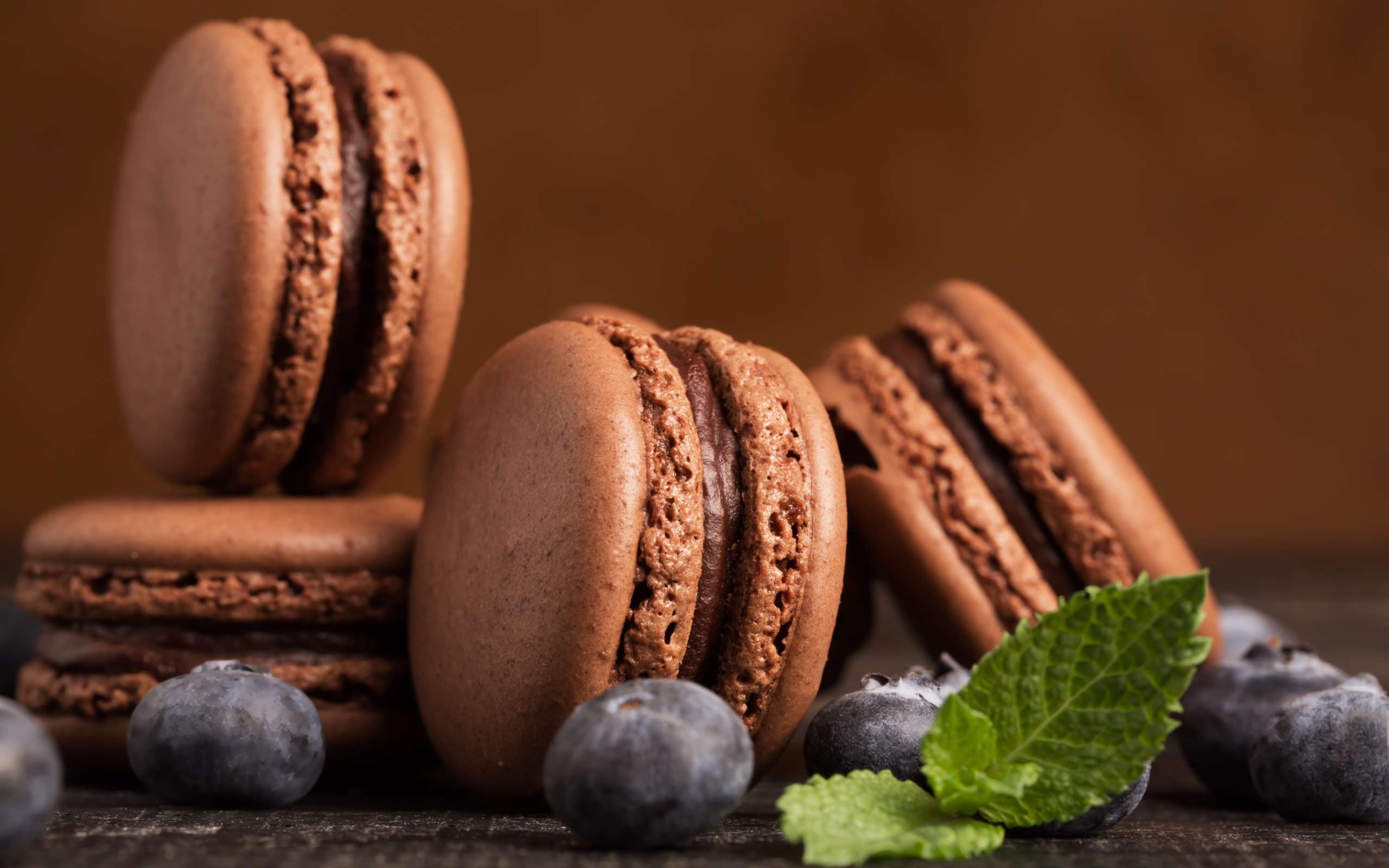 Шоколадный десерт макарон на столе с черникой 