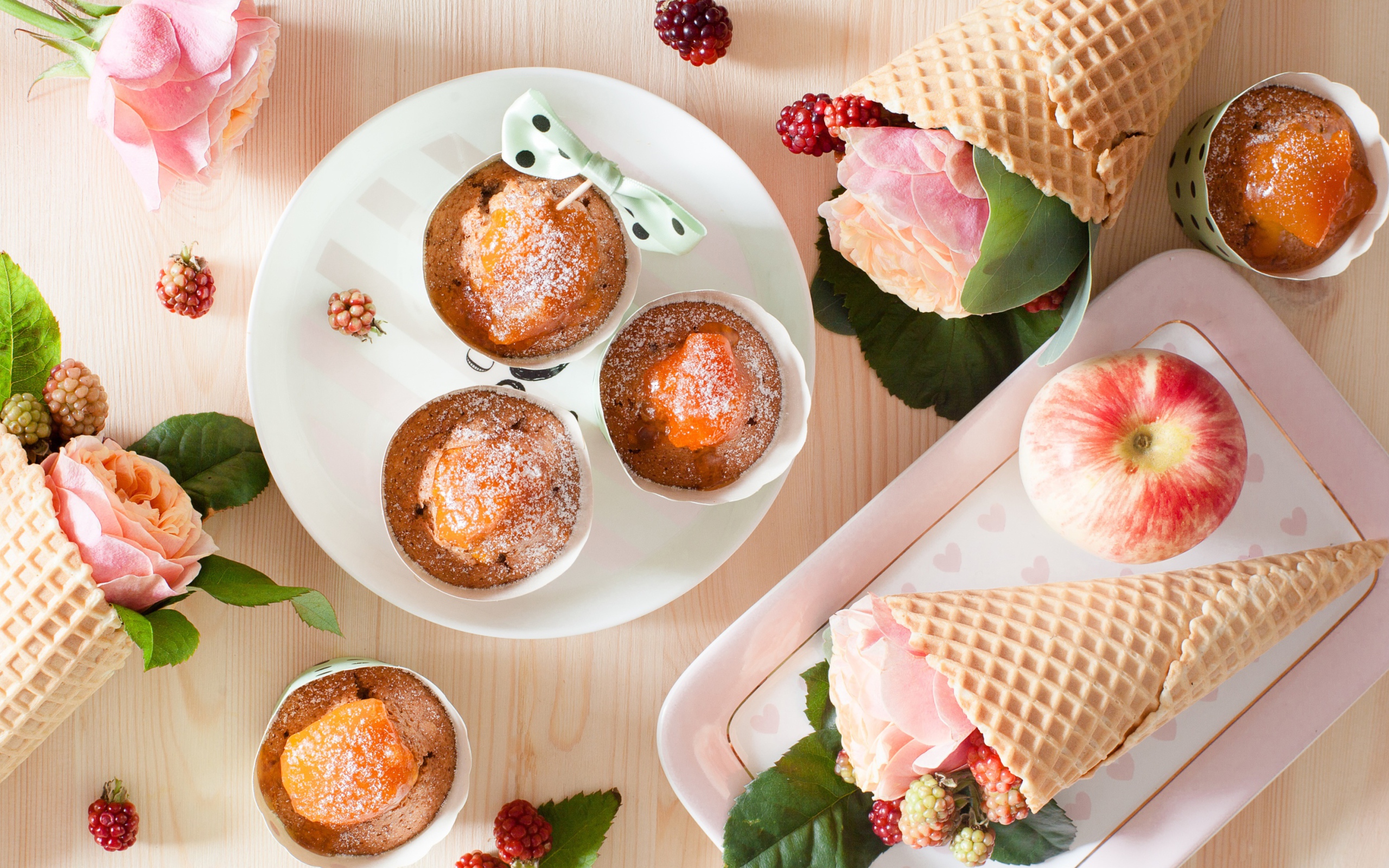 Вкусные кексы с абрикосом на столе с вафельными рожками с розой и ежевикой