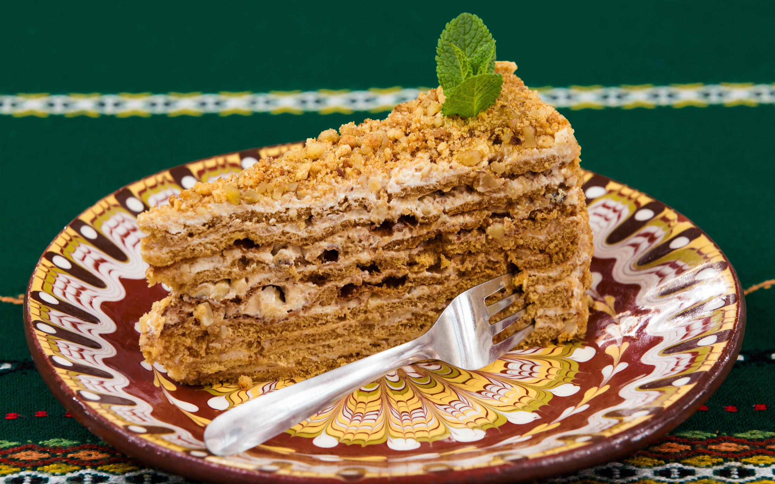 Вкусный медовый торт с орехами на красивой тарелке 