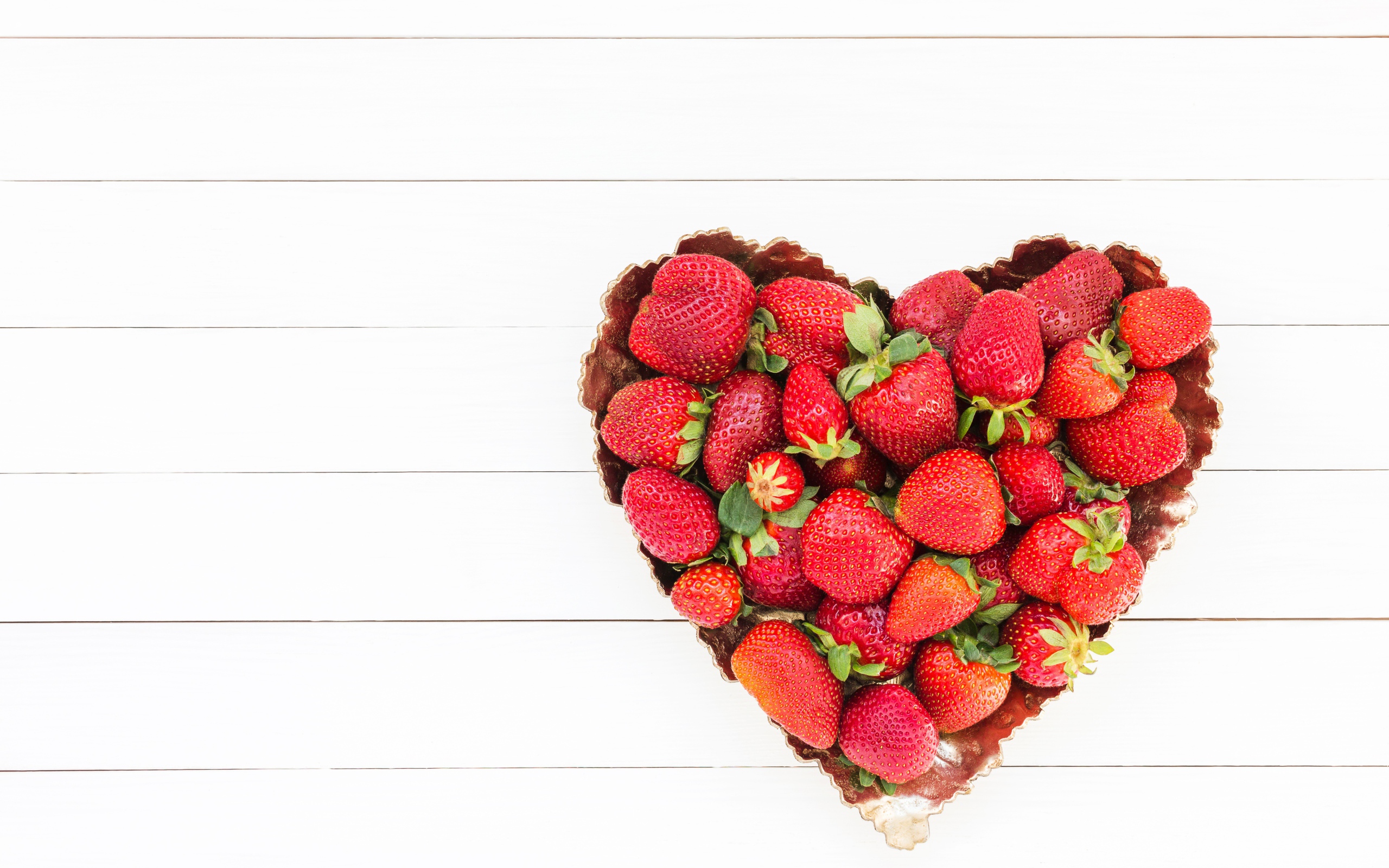 Пирожное в форме сердца с клубникой на белом фоне