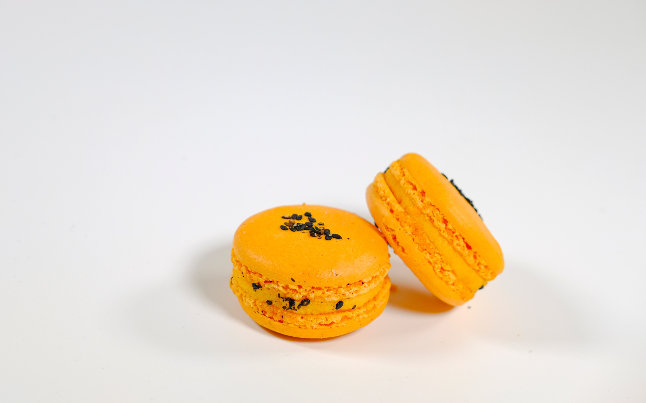 Оранжевый десерт макарон на сером фоне