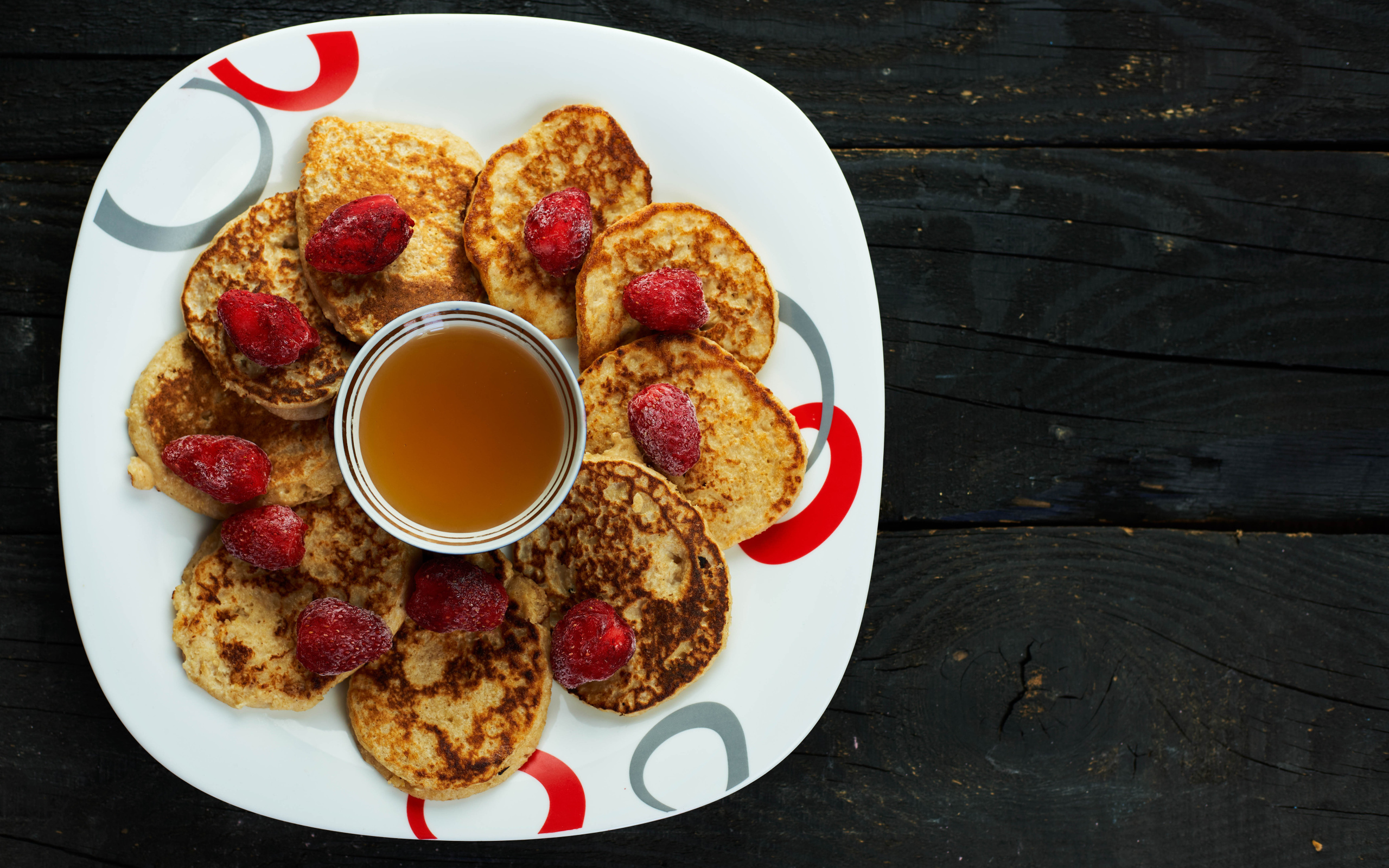 Оладьи на тарелке с клубникой и медом