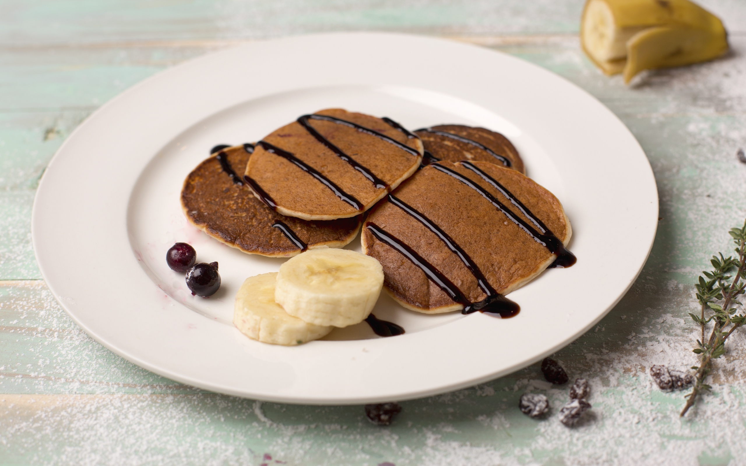 Румяные оладьи с бананом на белой тарелке 