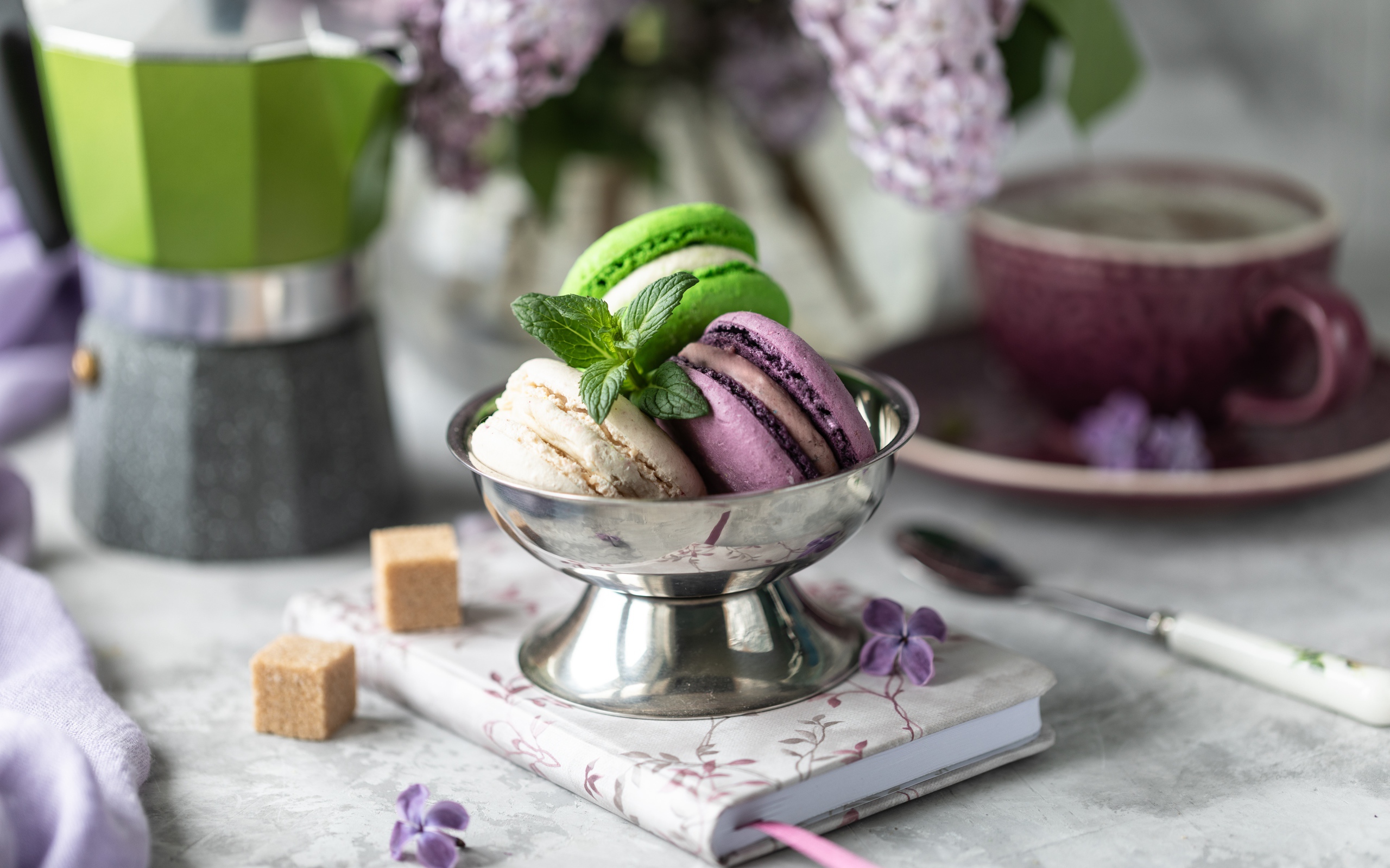 Три печенья макарун на столе с блокнотом