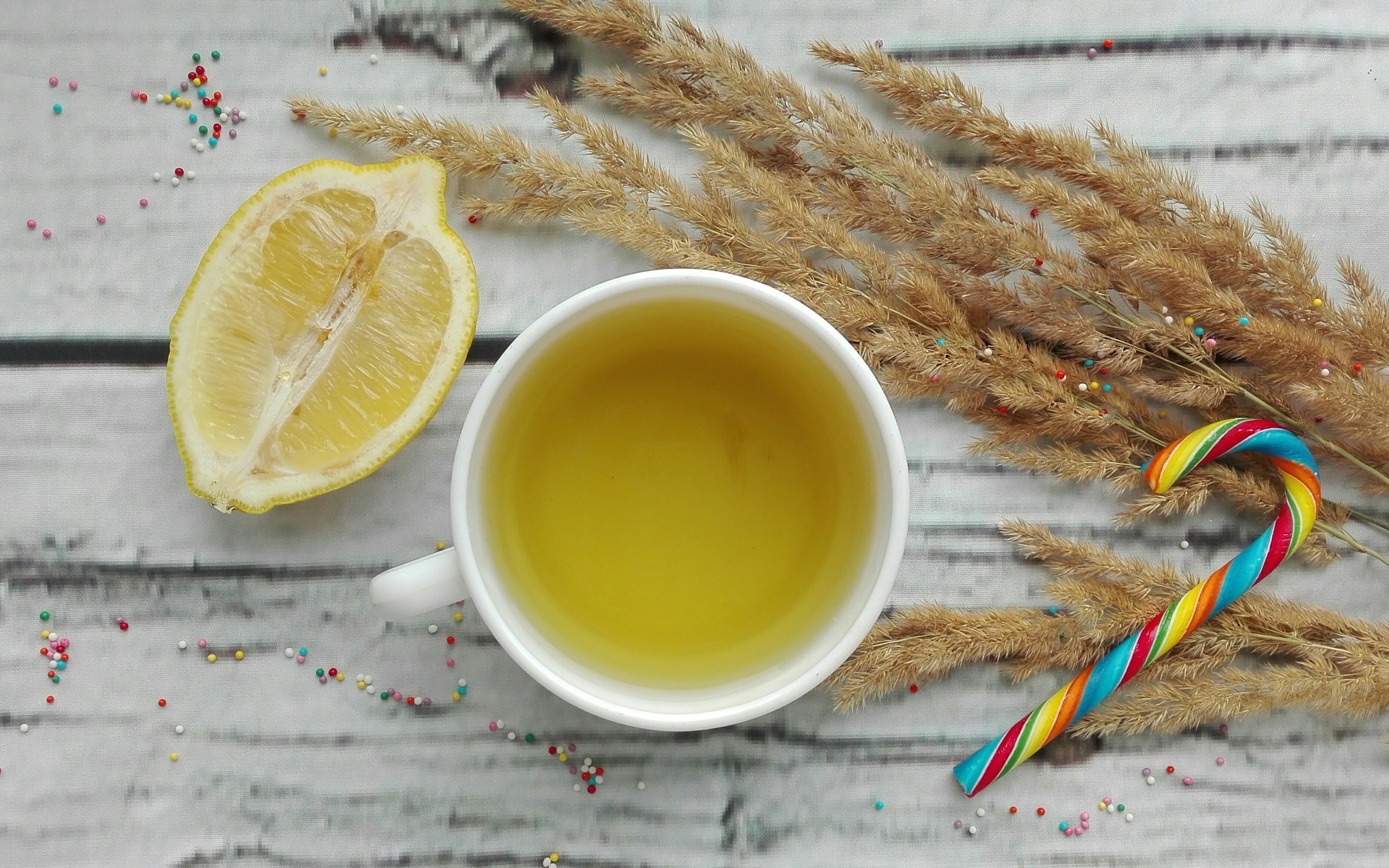 Чашка чая на столе с лимоном и колосьями