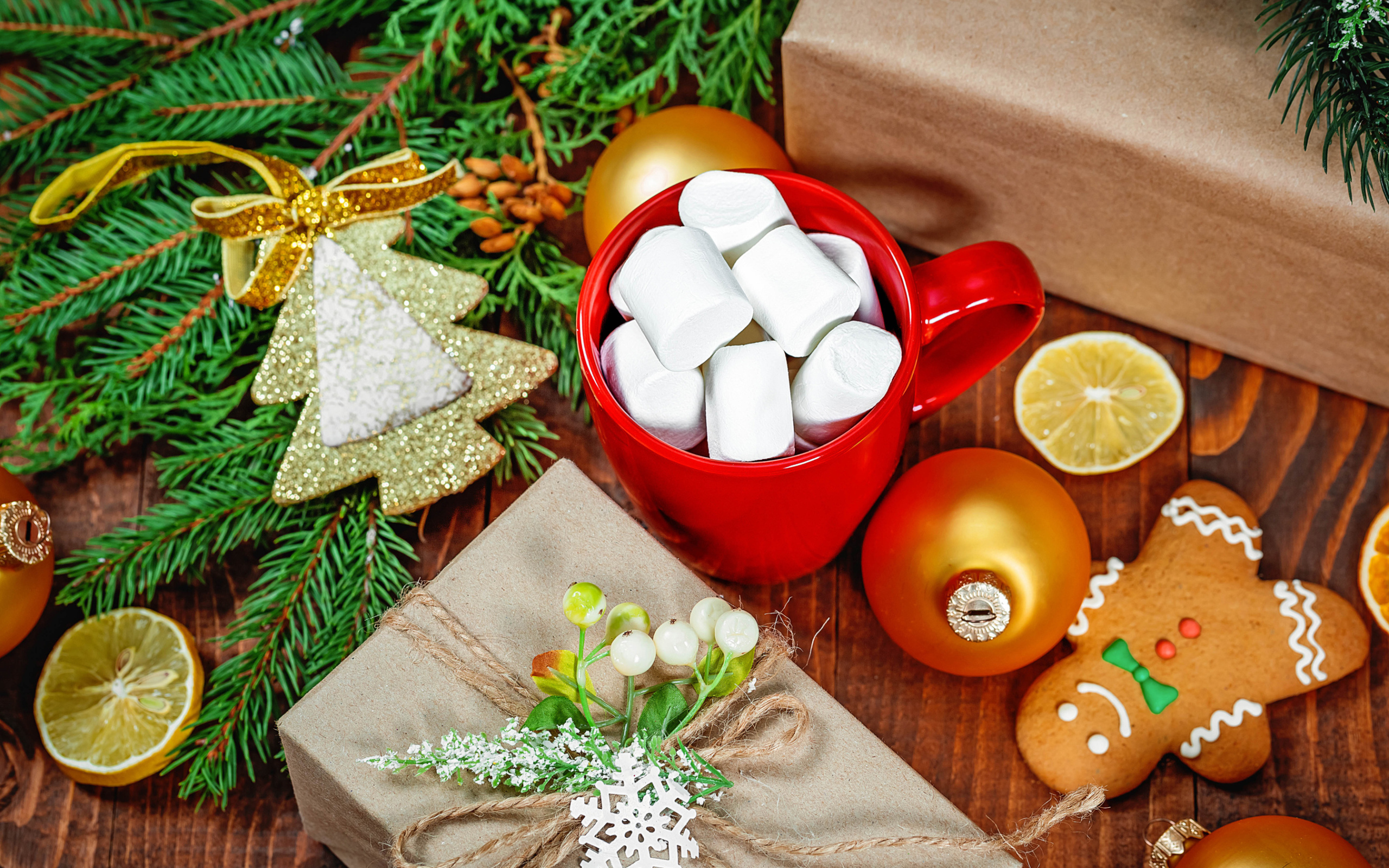 Чашка с маршмеллоу на столе с подарком, печеньем и еловой веткой