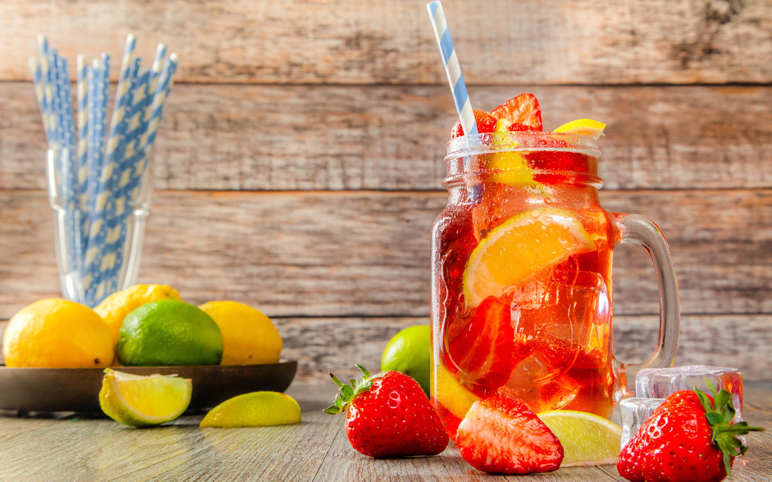 Напиток с клубникой и лимоном в банке на столе 