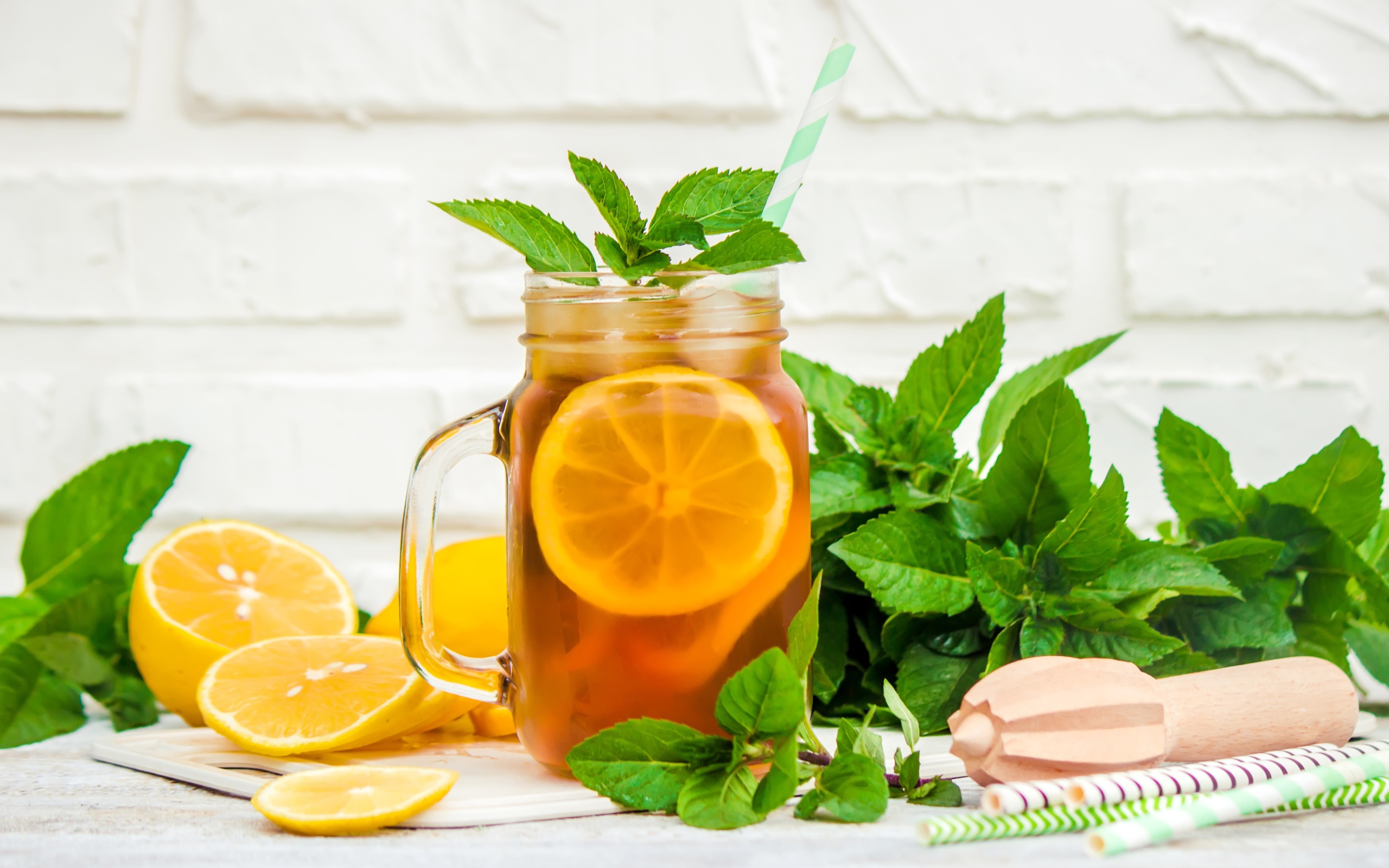 Лимонад на столе с лимоном и листьями мяты 