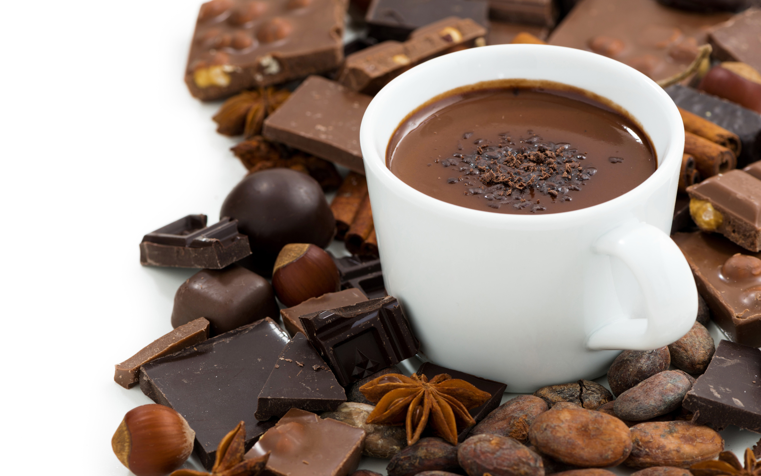 Белая чашка горячего шоколада на столе с шоколадом