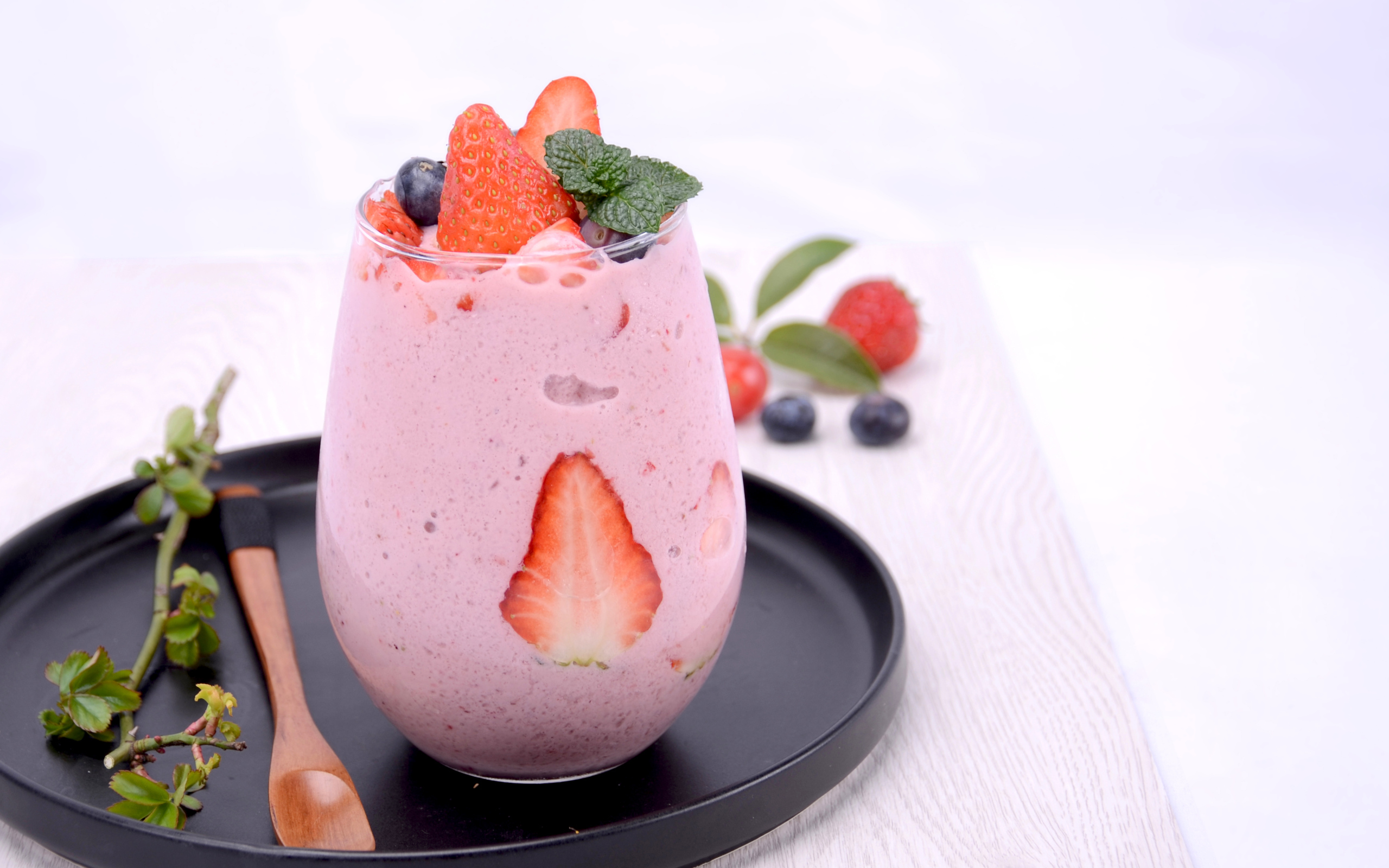 Йогурт в стакане с ягодами черники и клубники