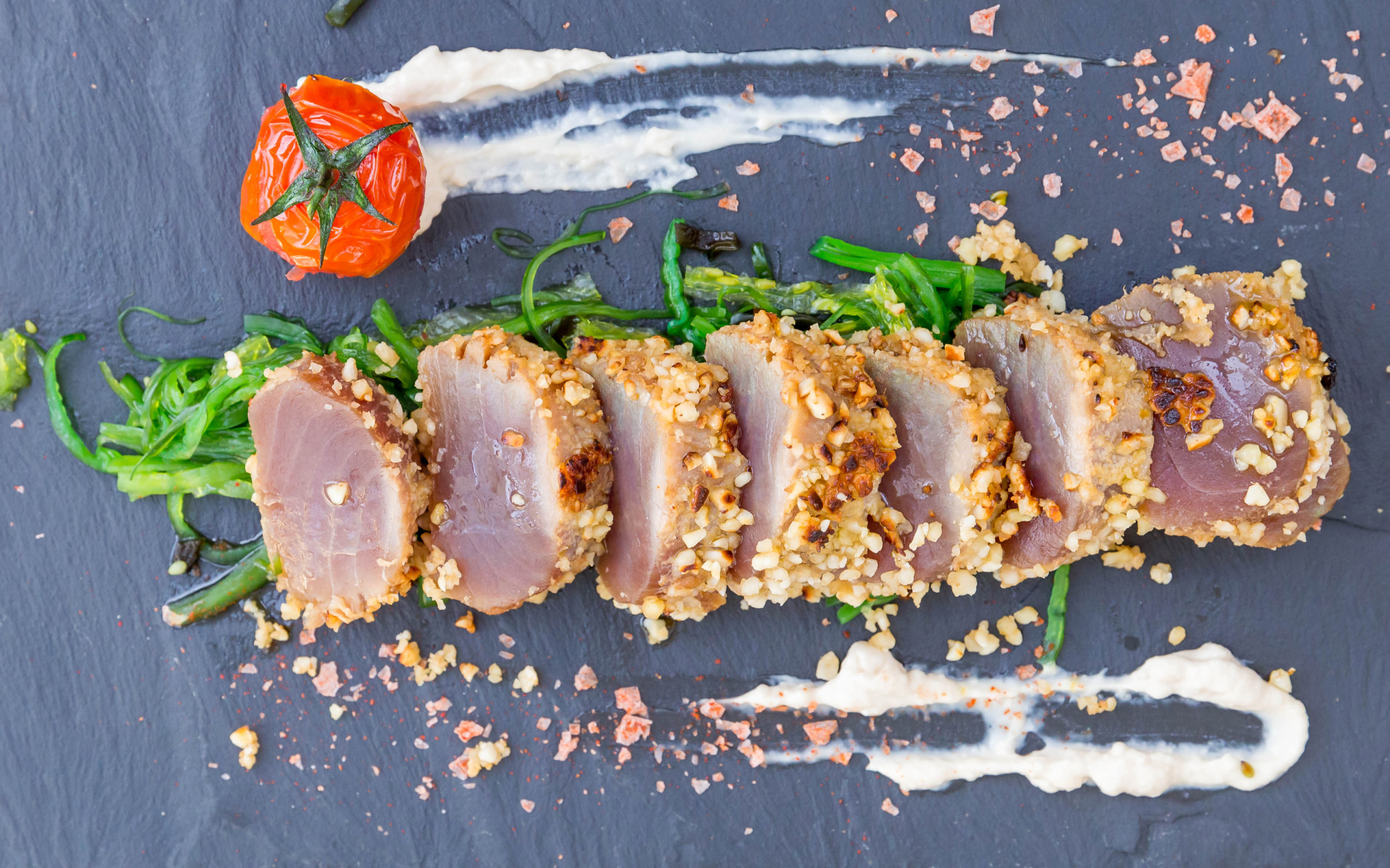 Вяленое мясо на столе с зеленью и помидором 