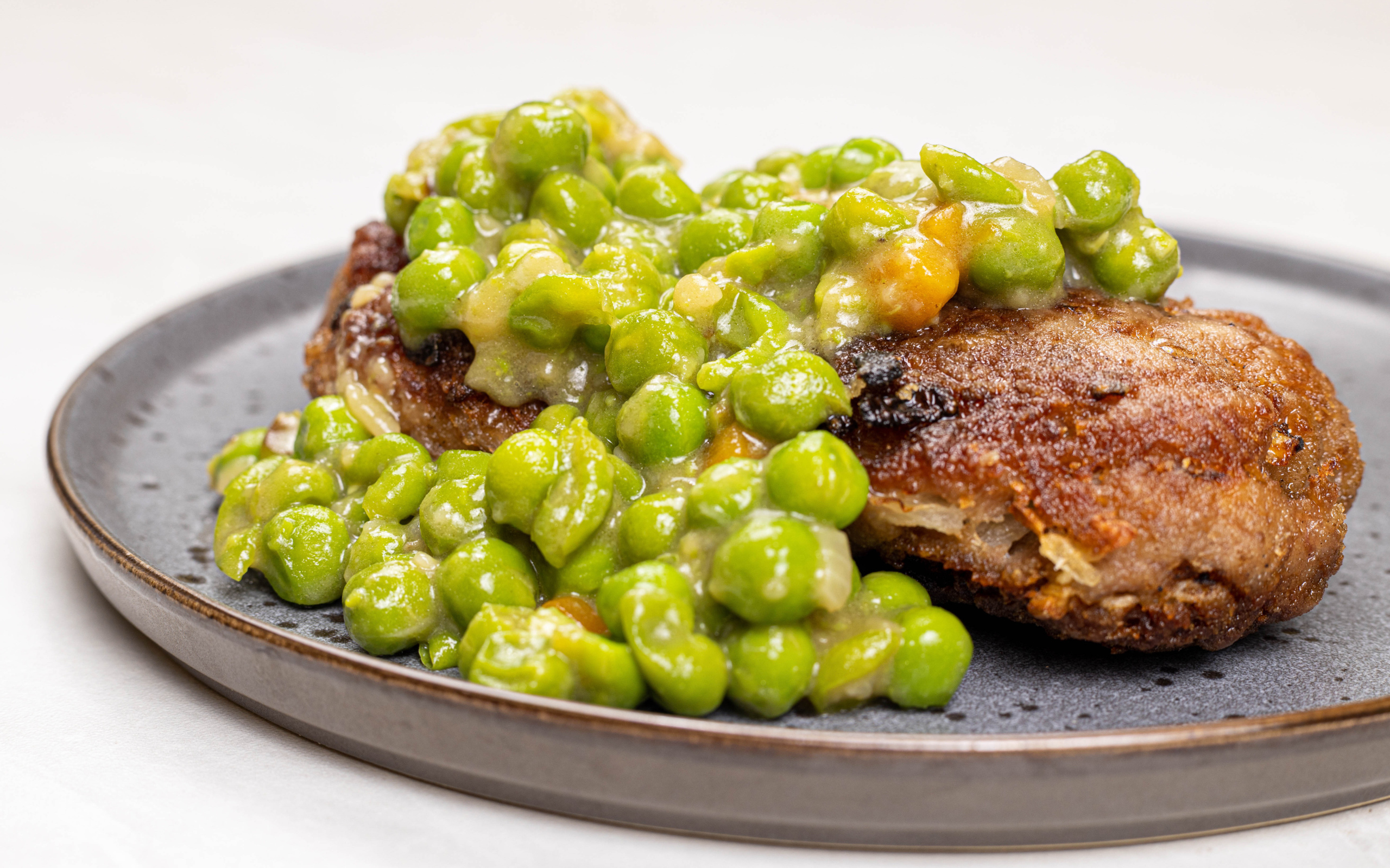 Котлета на тарелке с зеленым горошком