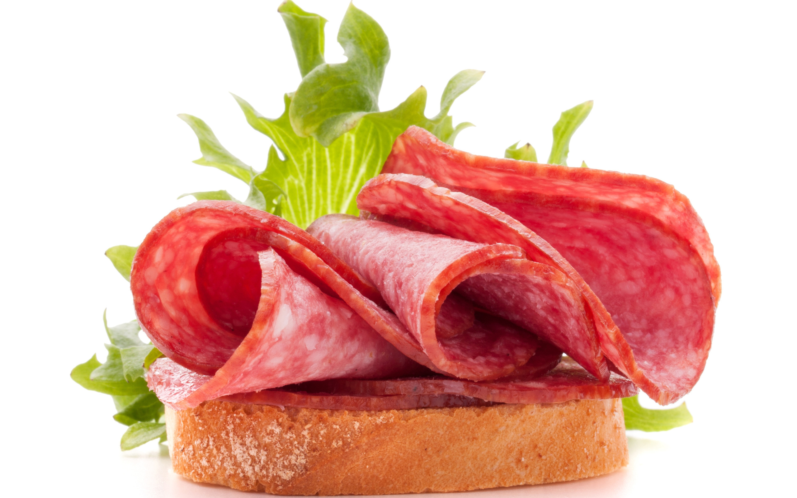 Бутерброд с листьями салата и колбасой на белом фоне