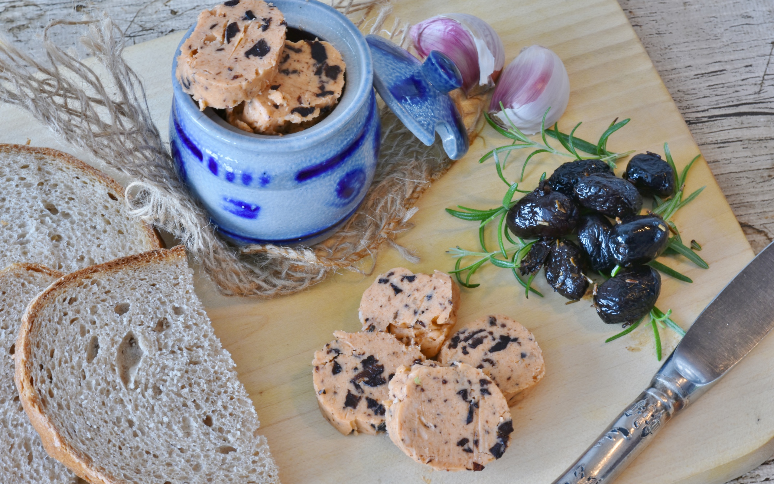 Колбаса с маслинами на столе с хлебом и чесноком