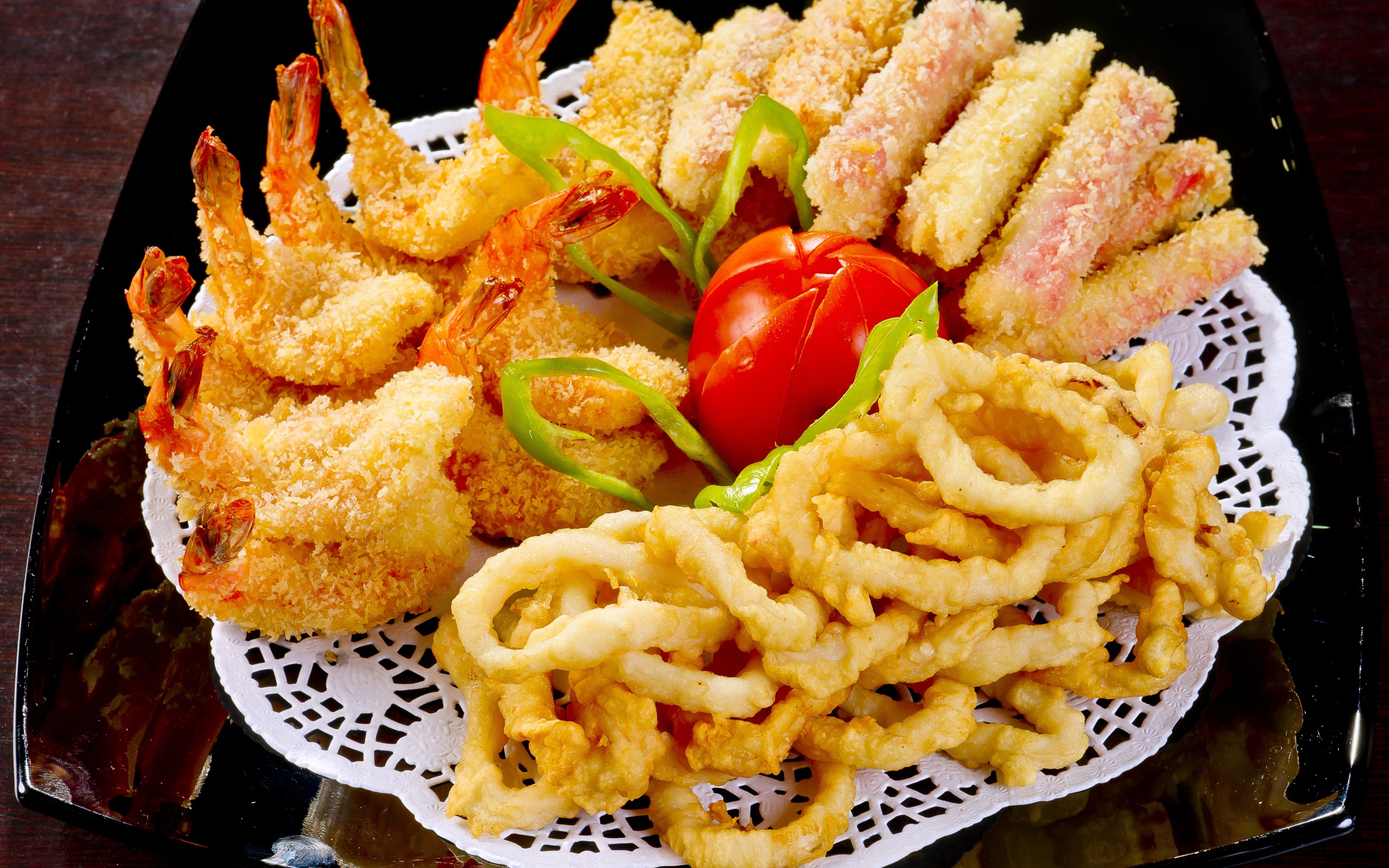 Морепродукты в кляре на тарелке с помидором